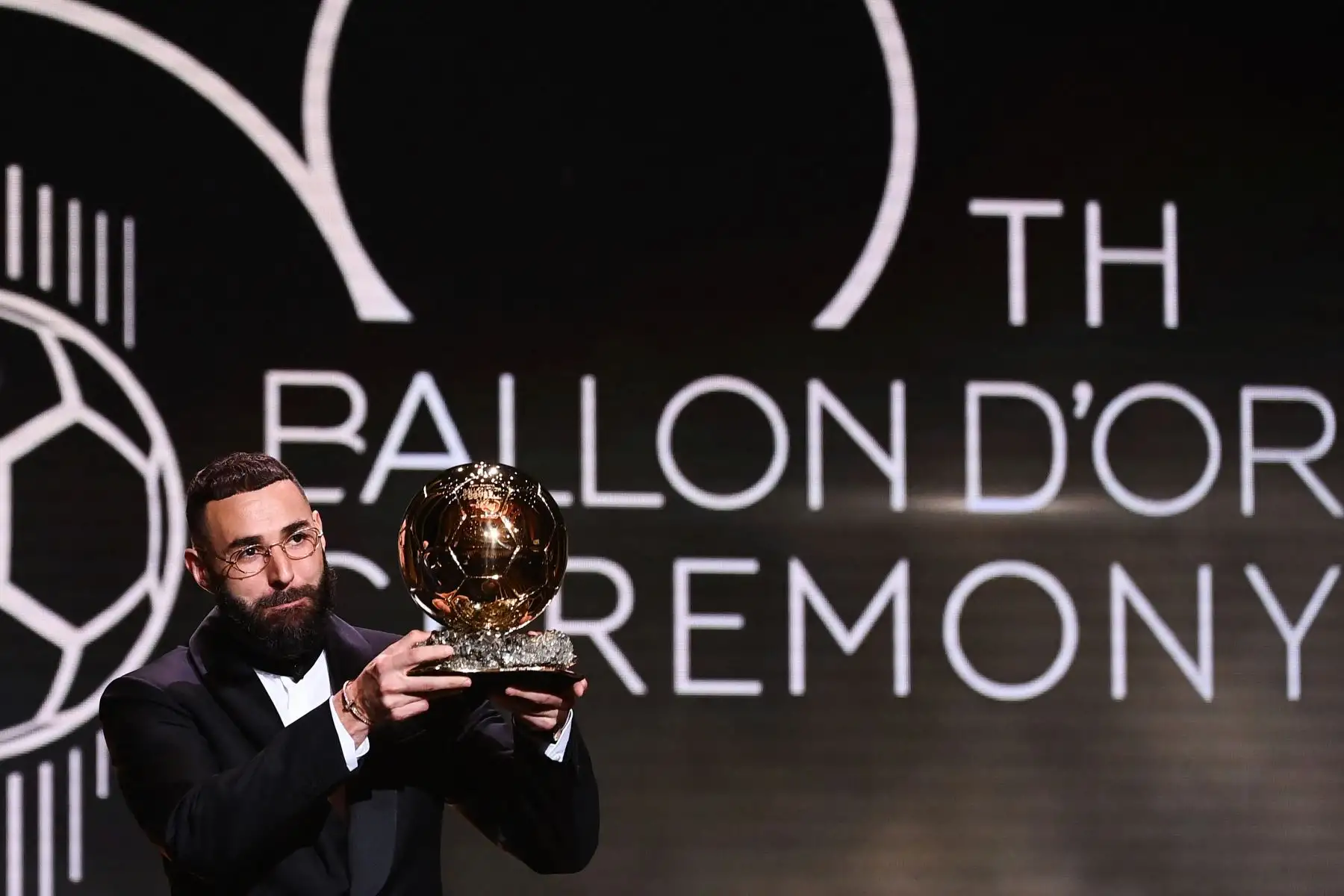 El delantero francés del Real Madrid, Karim Benzema, recibe el Balón de Oro de manos durante la ceremonia de entrega que se desarrolla en París. Foto: AFP