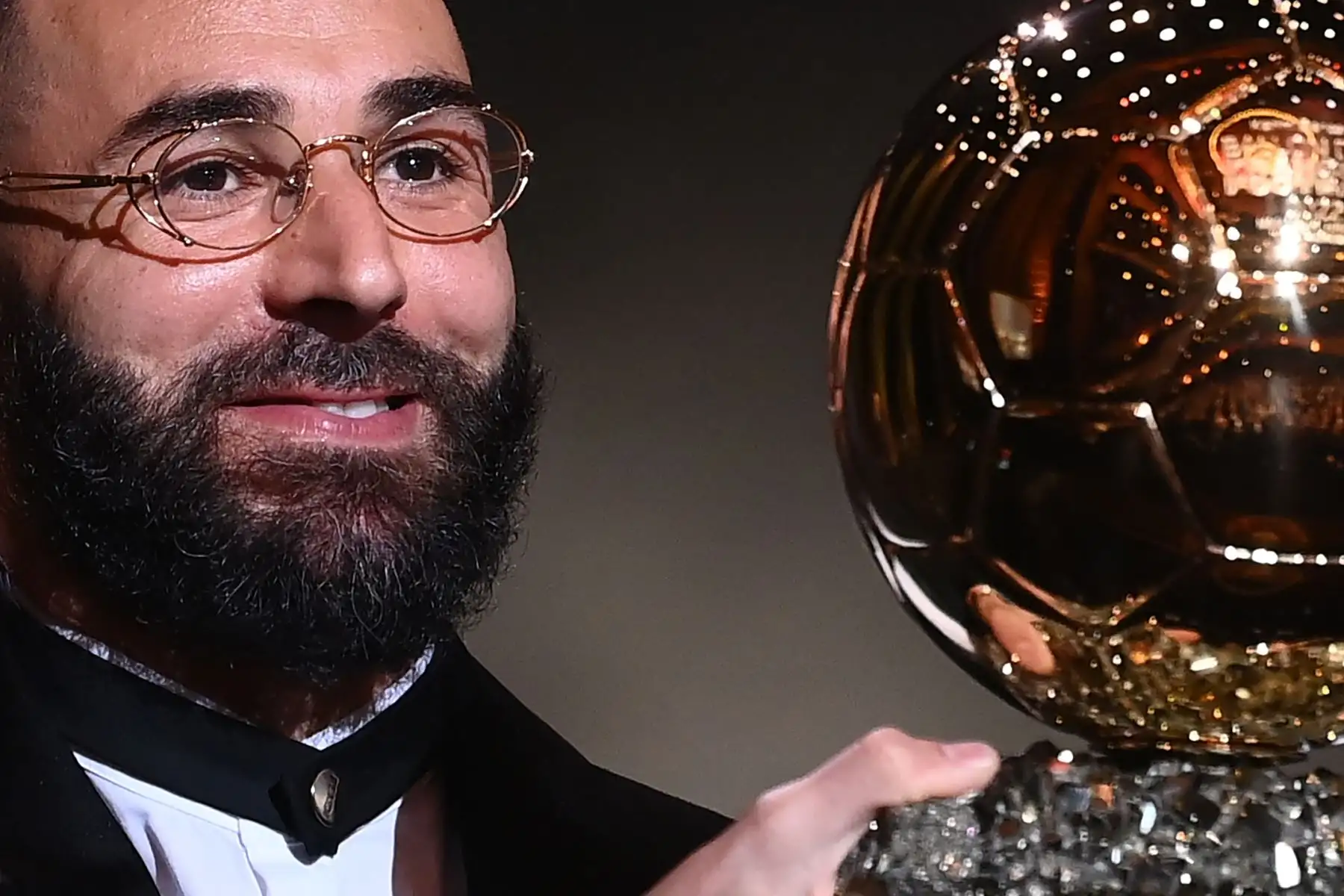 El delantero francés del Real Madrid, Karim Benzema, recibe el Balón de Oro de manos durante la ceremonia de entrega que se desarrolla en París. Foto: AFP