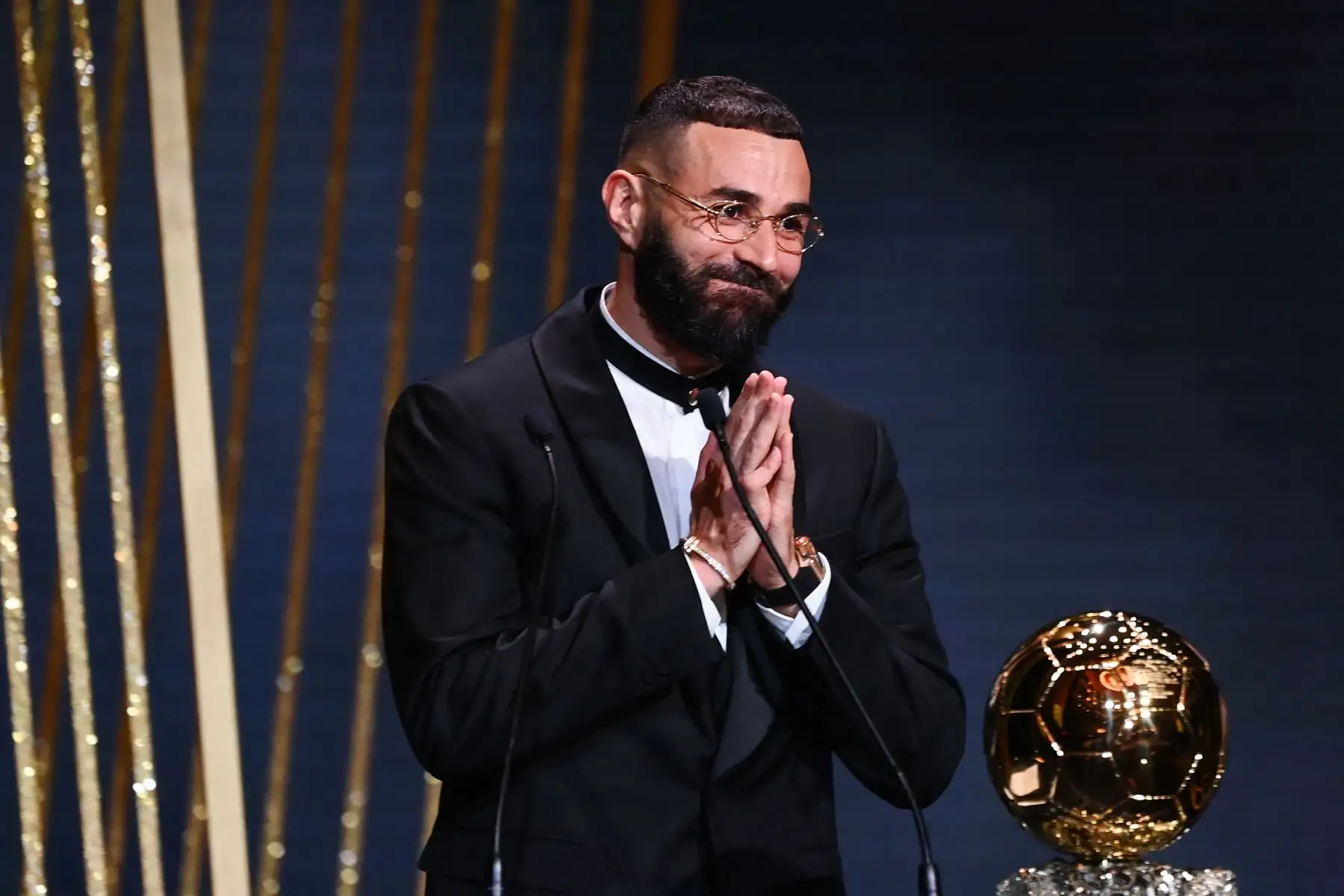 El delantero francés del Real Madrid, Karim Benzema, recibe el Balón de Oro de manos durante la ceremonia de entrega que se desarrolla en París. Foto: AFP