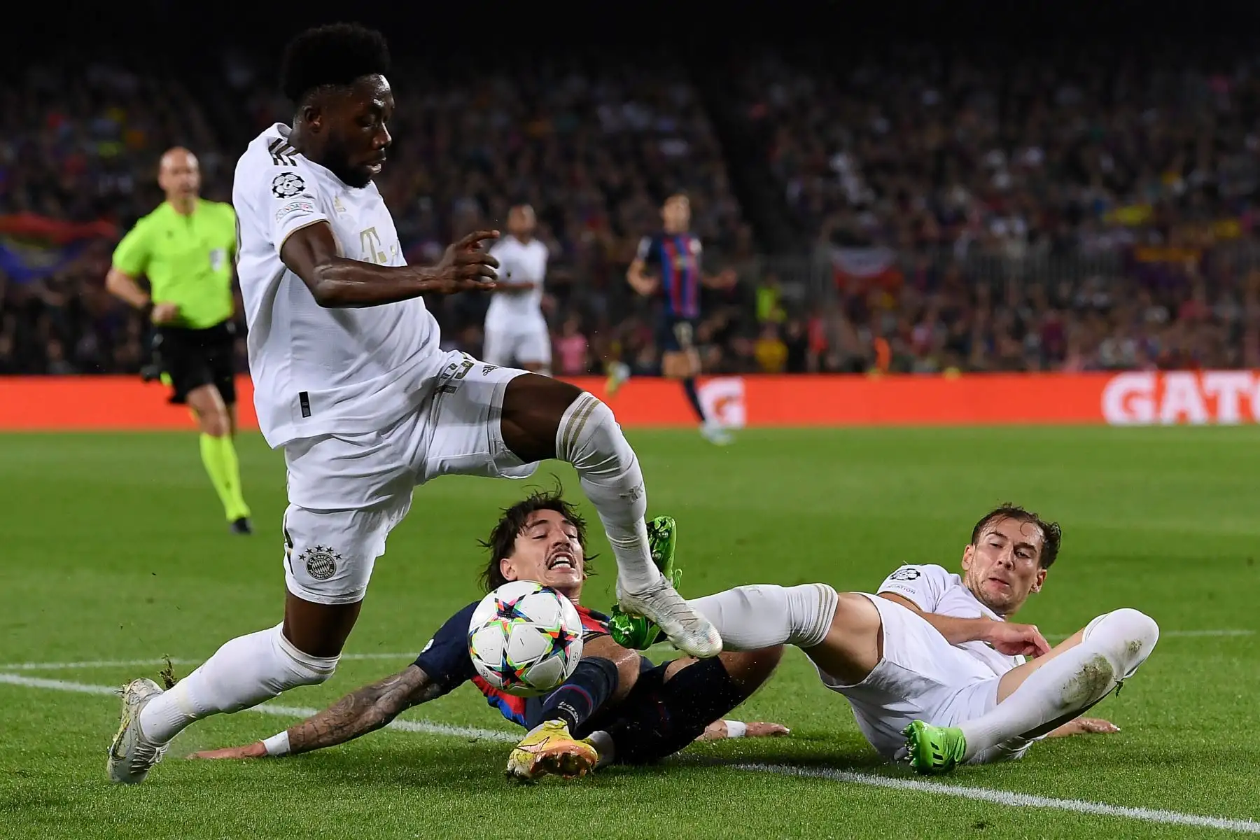 El defensor español de Barcelona, ​​Héctor Bellerin (C), lucha por el balón con el centrocampista  del Bayern de Múnich, Alphonso Davies (L), y el centrocampista alemán del Bayern de Múnich, Joshua Kimmich, durante la primera ronda de la Liga de Campeones de la UEFA, día 5,  entre el FC Barcelona y el FC Bayern de Múnich.Foto: AFP