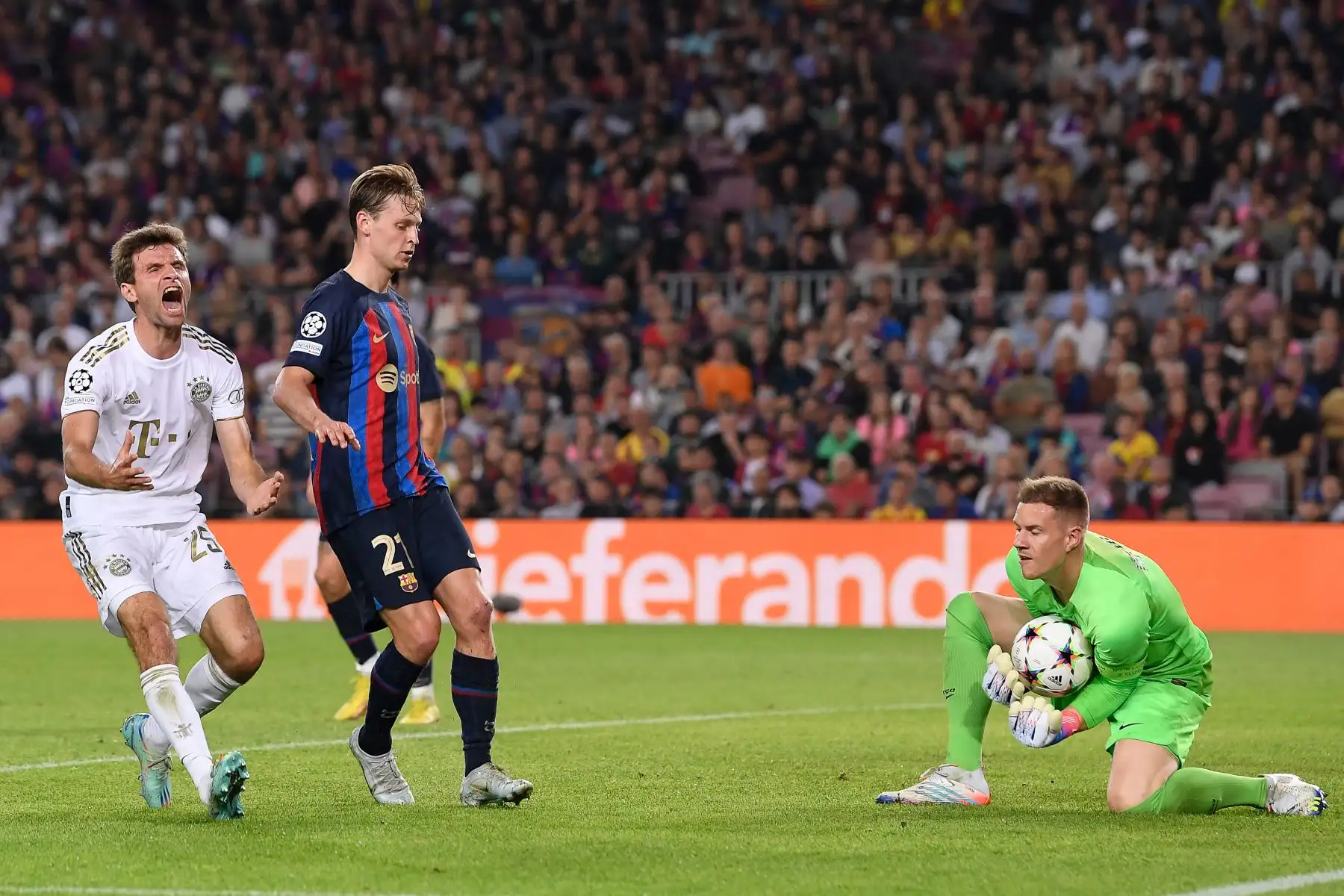 El delantero del Bayern de Múnich, Thomas Mueller , reacciona junto al centrocampista  del Barcelona, Frenkie De Jong, mientras el portero del Barcelona, Marc-Andre ter Stegen, agarra el balón durante la primera ronda de la Liga de Campeones de la UEFA, día 5,entre el FC Barcelona y FC Bayern Múnich. AFP