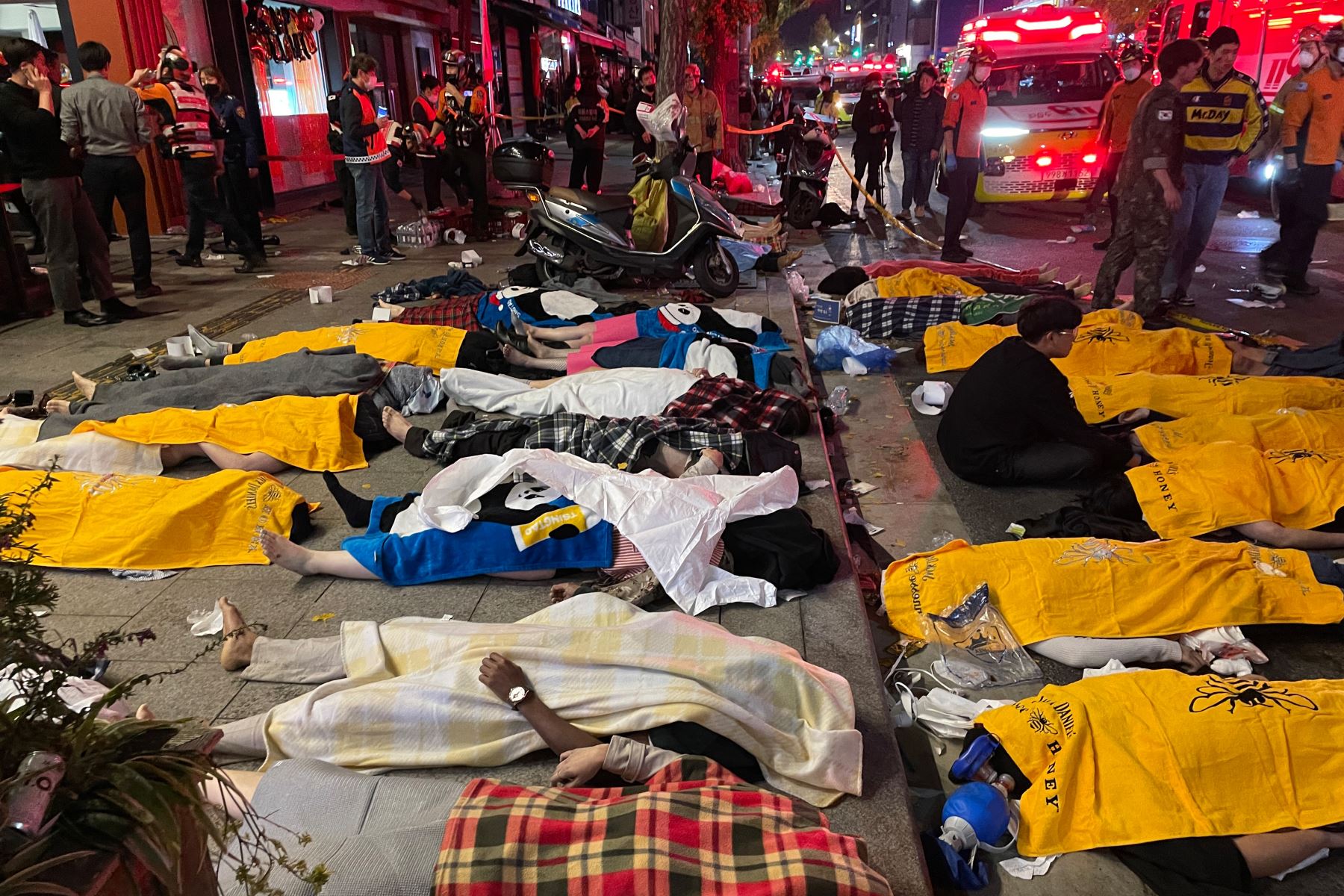 En la imagen se aprecia los cuerpos de las víctimas que se cree que sufrieron un paro cardíaco durante una estampida en medios de las celebraciones por Halloween, en el popular distrito de vida nocturna de Itaewon, en Seúl. Foto: AFP