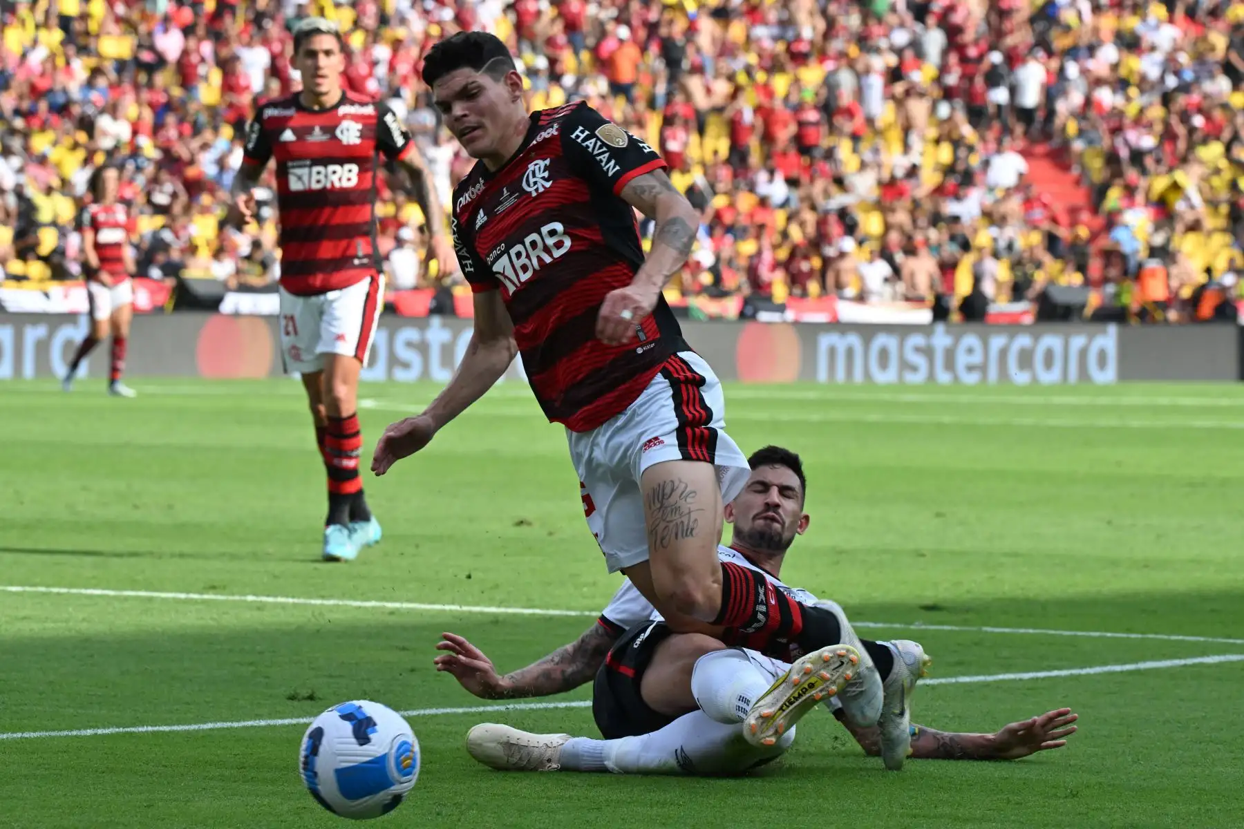 El defensa brasileño del Athletico Paranaense, Pedro Henrique, comete una falta sobre el defensa brasileño del Flamengo, Ayrton, durante la final de la Copa Libertadores. Foto: AFP