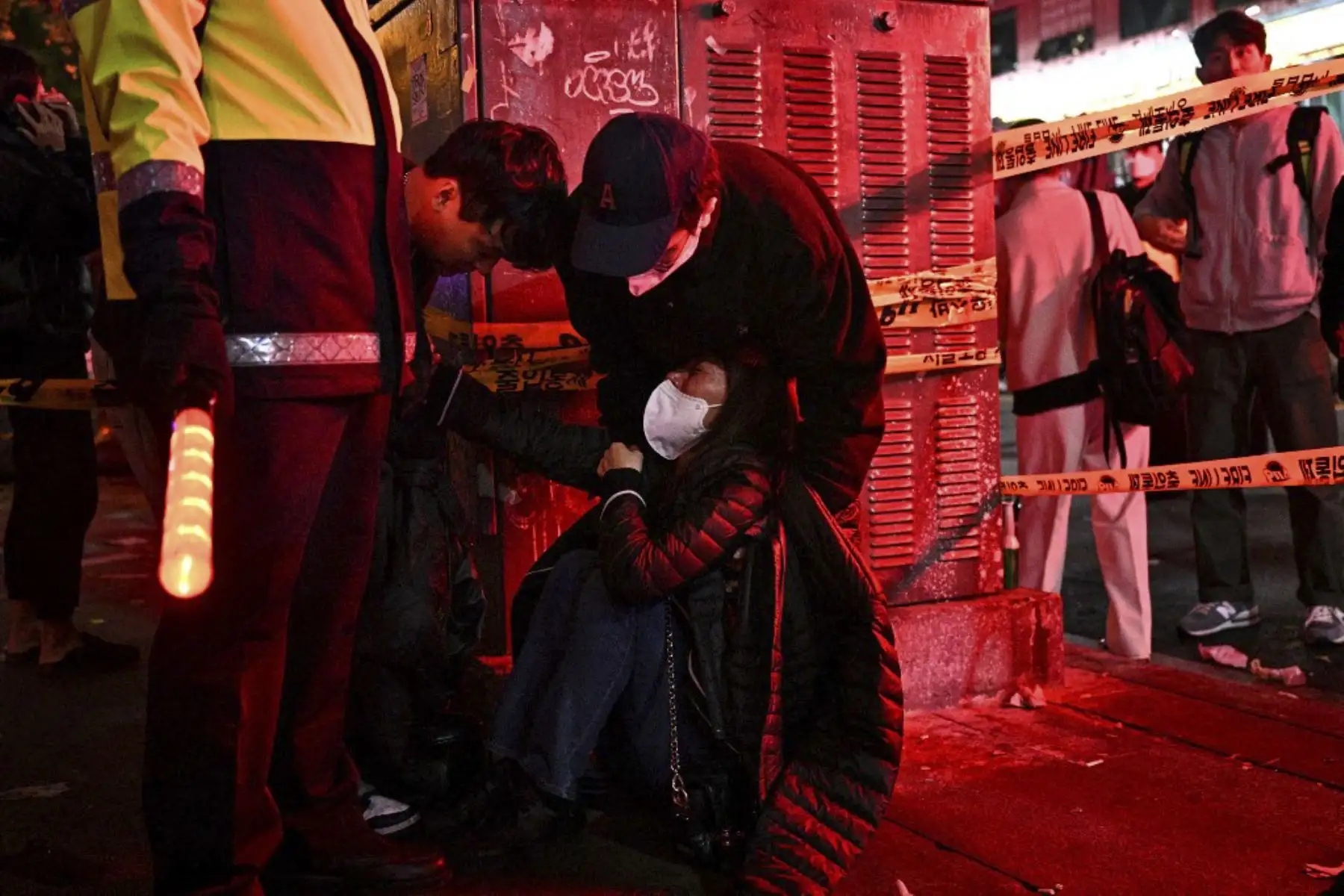 Una mujer es atendida mientras decenas de personas sufrían un paro cardíaco en el popular distrito de vida nocturna de Itaewon en Seúl

Foto: AFP