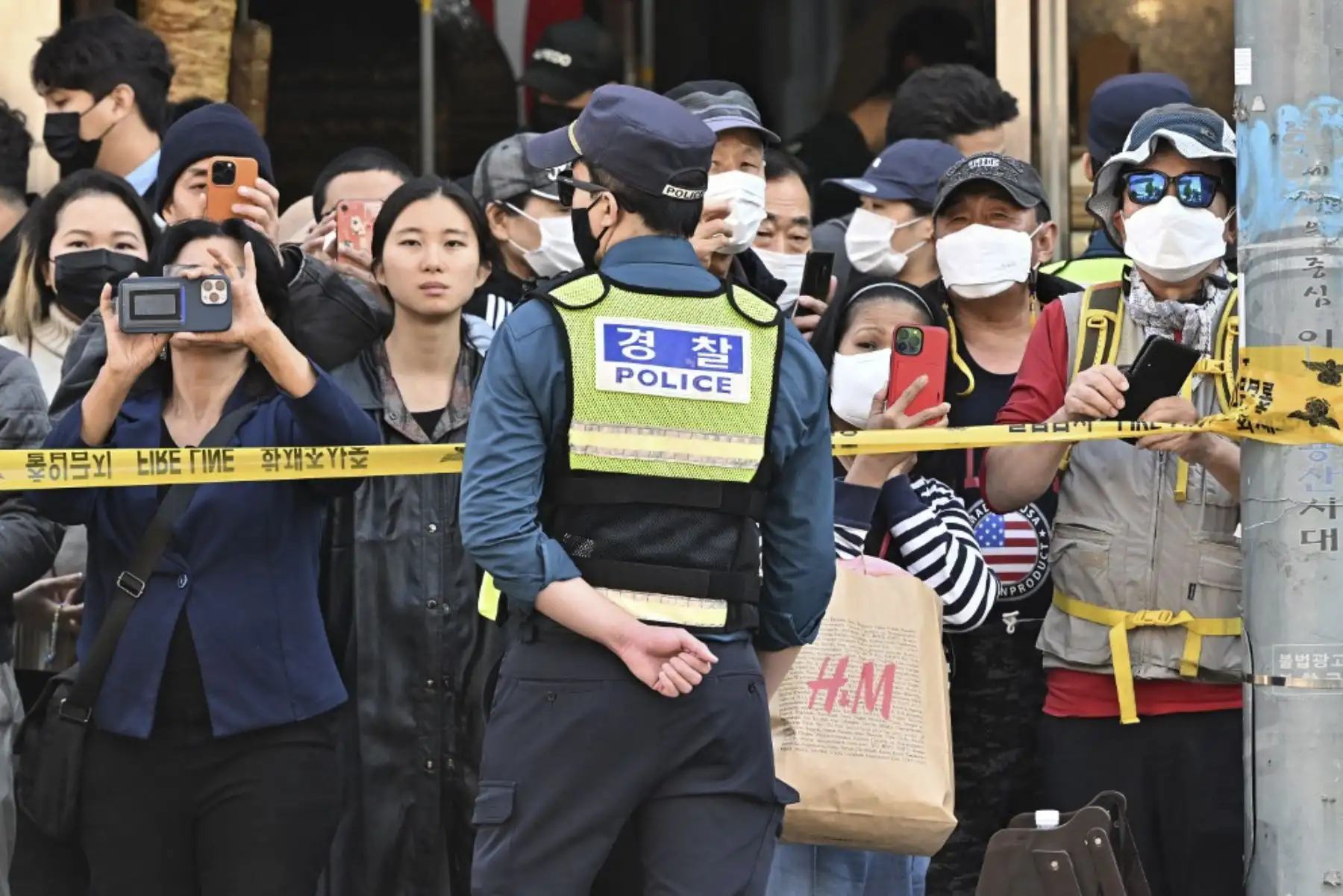 La gente mira la escena allí donde ocurrió la estampida de Halloween en el popular distrito de Itaewon de la capital en Seúl

Foto: AFP