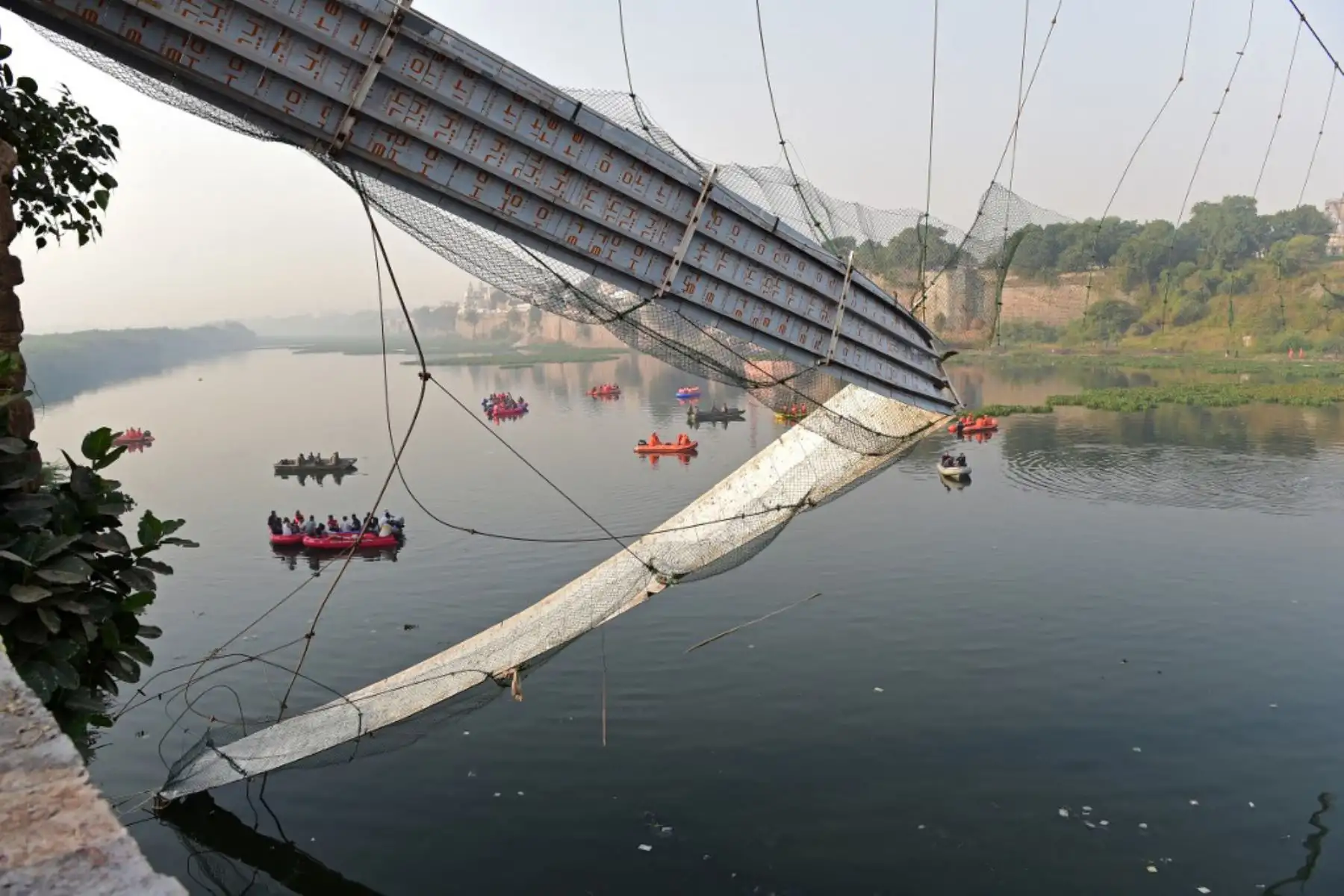 El personal de rescate realiza operaciones de búsqueda después de que un puente que cruza el río Machchhu se derrumbara en Morbi, en el estado indio de Gujarat. Foto: AFP