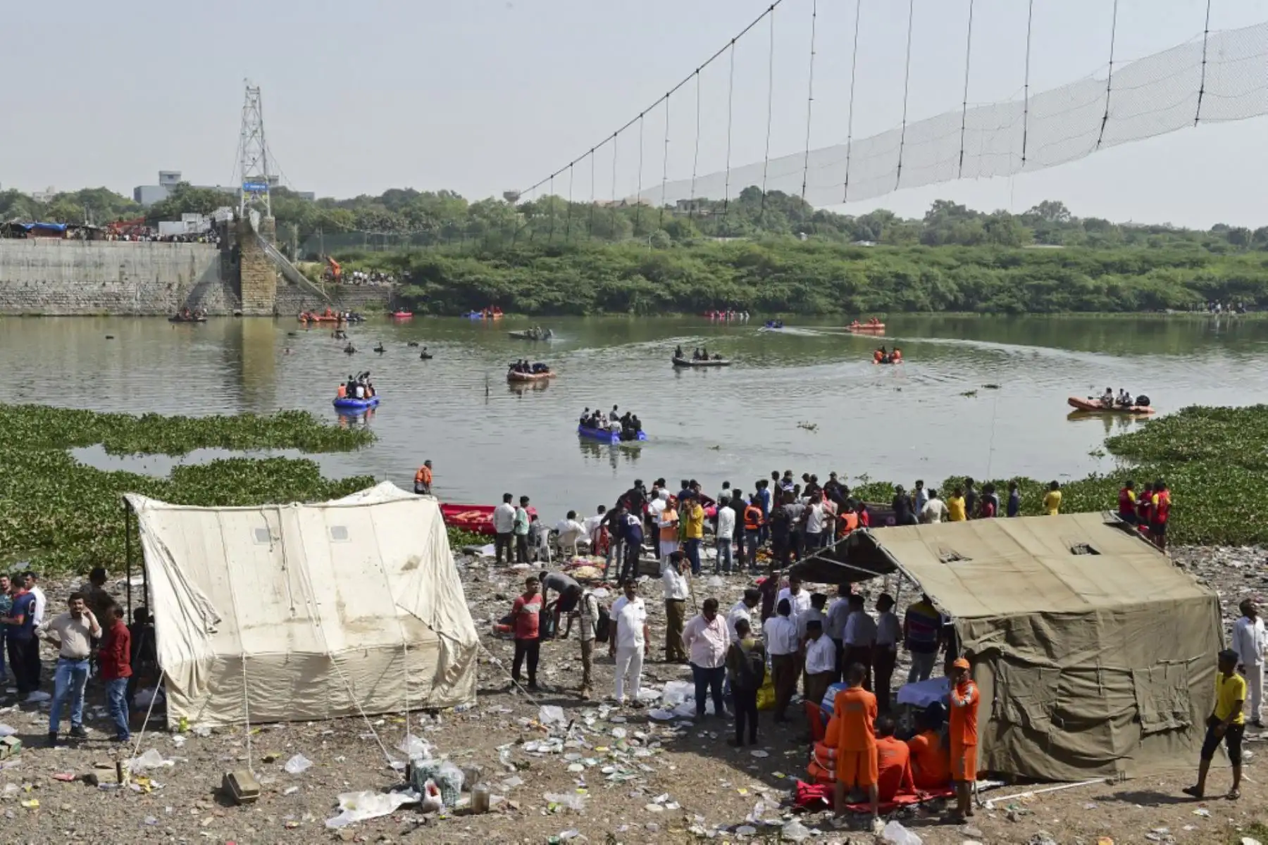 El personal de rescate realiza operaciones de búsqueda después de que un puente que cruza el río Machchhu se derrumbara en Morbi, en el estado indio de Gujarat. Foto: AFP