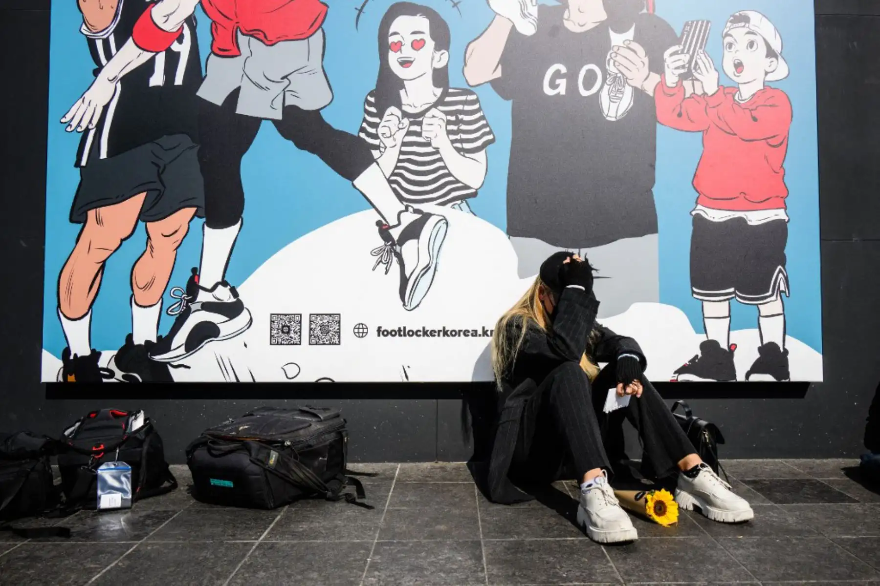 Una mujer llora cerca de un monumento improvisado afuera de una estación de metro en el distrito de Itaewon en Seúl. Foto: AFP