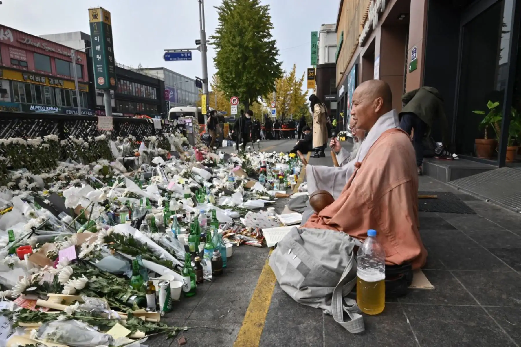 Monjes budistas de Corea del Sur rezan en un memorial improvisado por las víctimas de la mortal oleada de multitudes de Halloween, afuera de una estación de metro en el distrito de Itaewon en Seúl. Foto: AFP