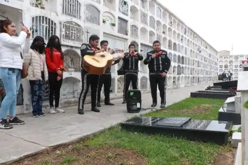 Un conjunto de mariachis acompaña a una familia trujillana en su visita a un ser querido en el cementerio. Foto: Luis Puell ANDINA