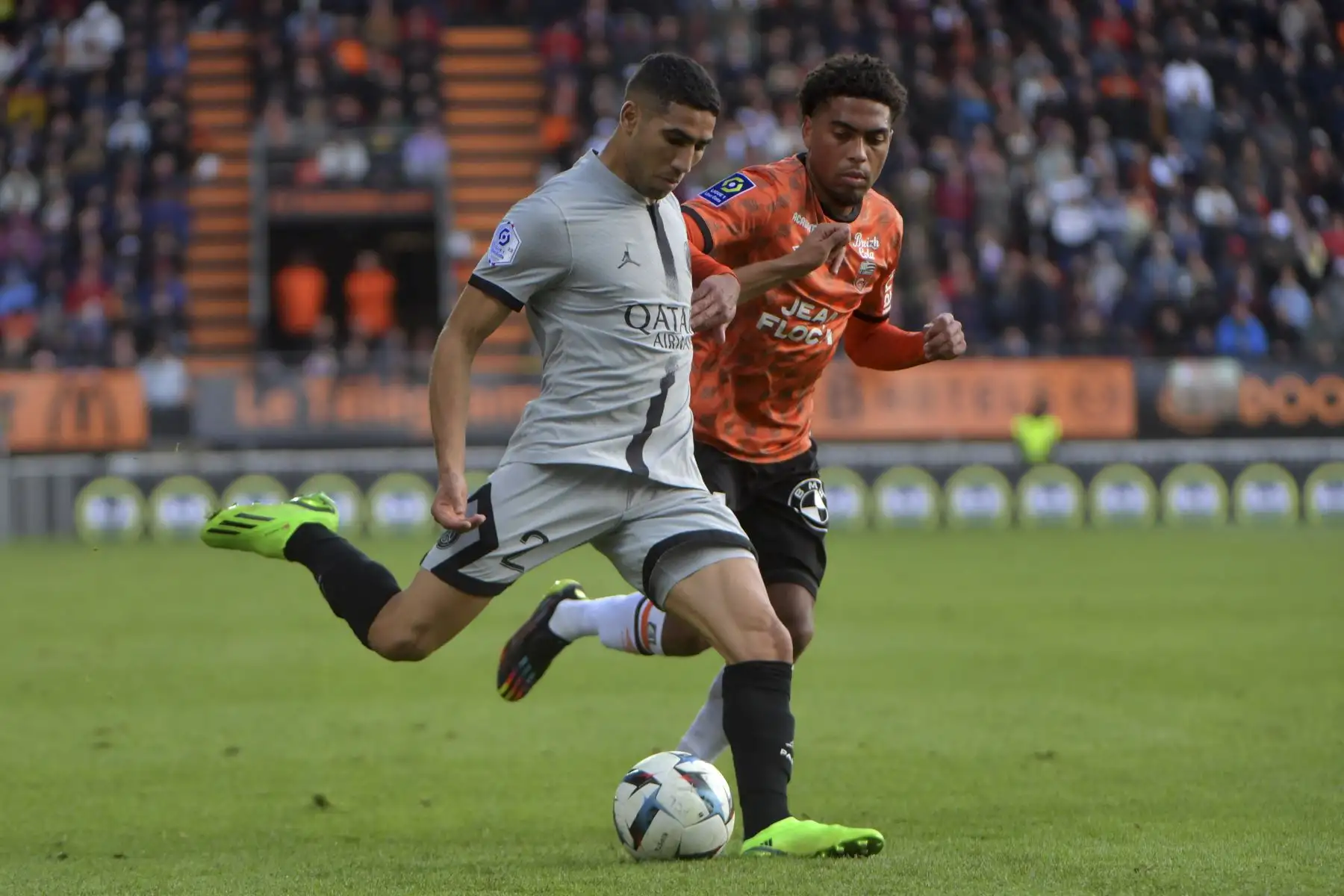 El defensa marroquí del Paris Saint-Germain, Achraf Hakimi, lucha por el balón con el mediocampista francés del Lorient, Julien Ponceau, durante el partido de la liga francesa. Foto: AFP