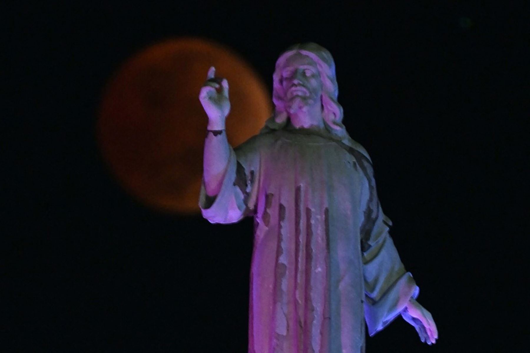 La luna de sangre se ve durante un eclipse lunar total más allá del monumento del Salvador del Mundo, en San Salvador. Foto: AFP