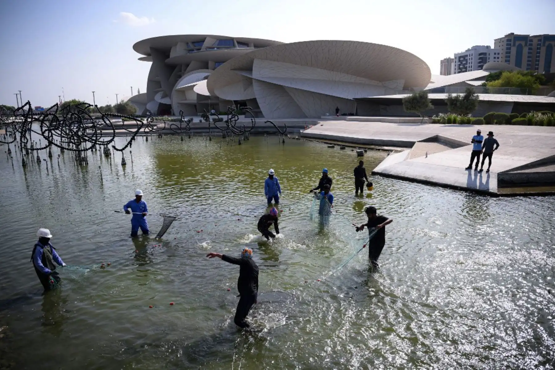 Los trabajadores atrapan peces voladores frente al Museo Nacional de Qatar en Doha, antes del torneo de fútbol de la Copa Mundial de Qatar 2022. Foto: AFP
