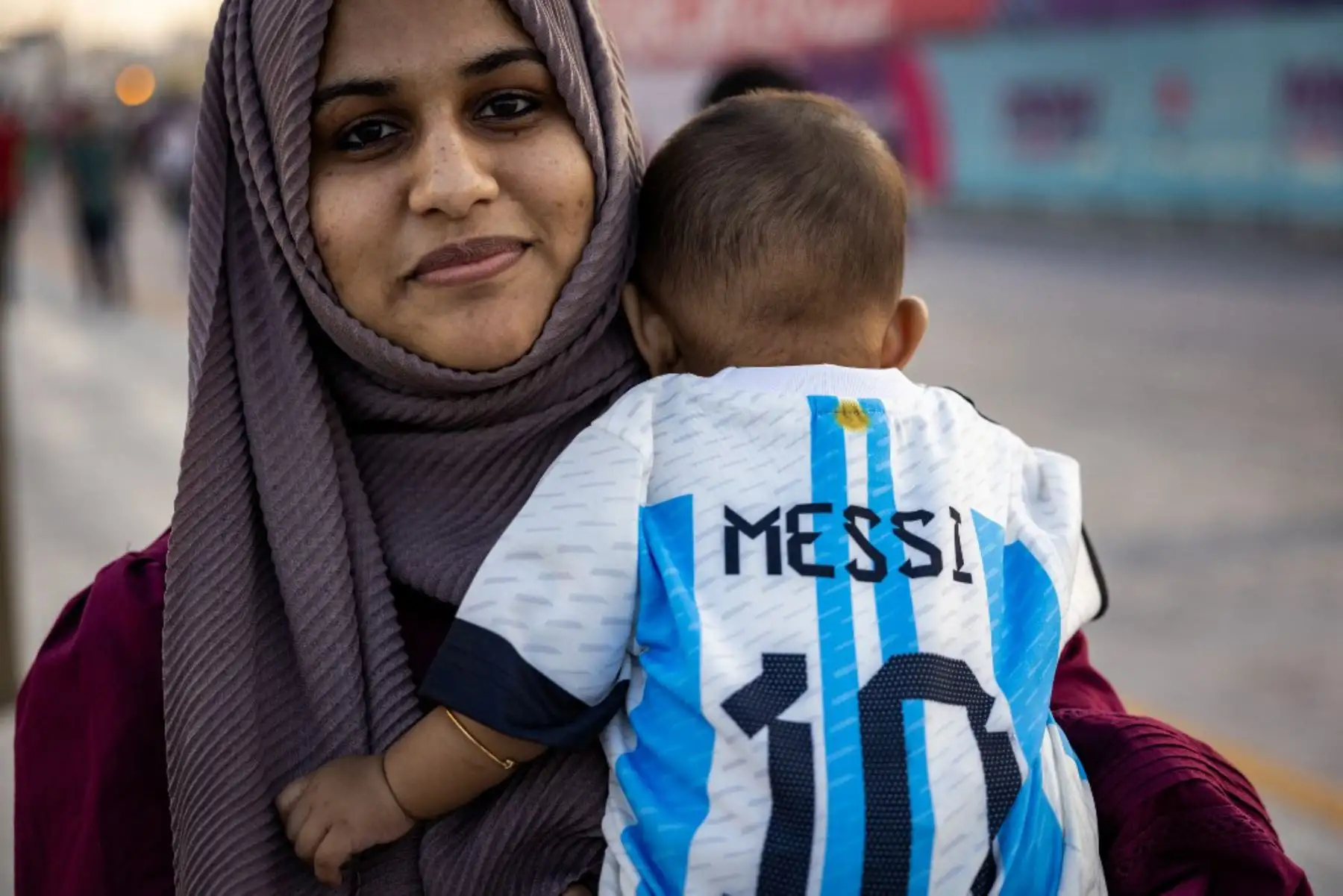 Un fanático del fútbol que apoya a Argentina con su hijo camina por un paseo marítimo en Doha , antes del torneo de fútbol de la Copa Mundial de la FIFA Qatar 2022. Foto: AFP
