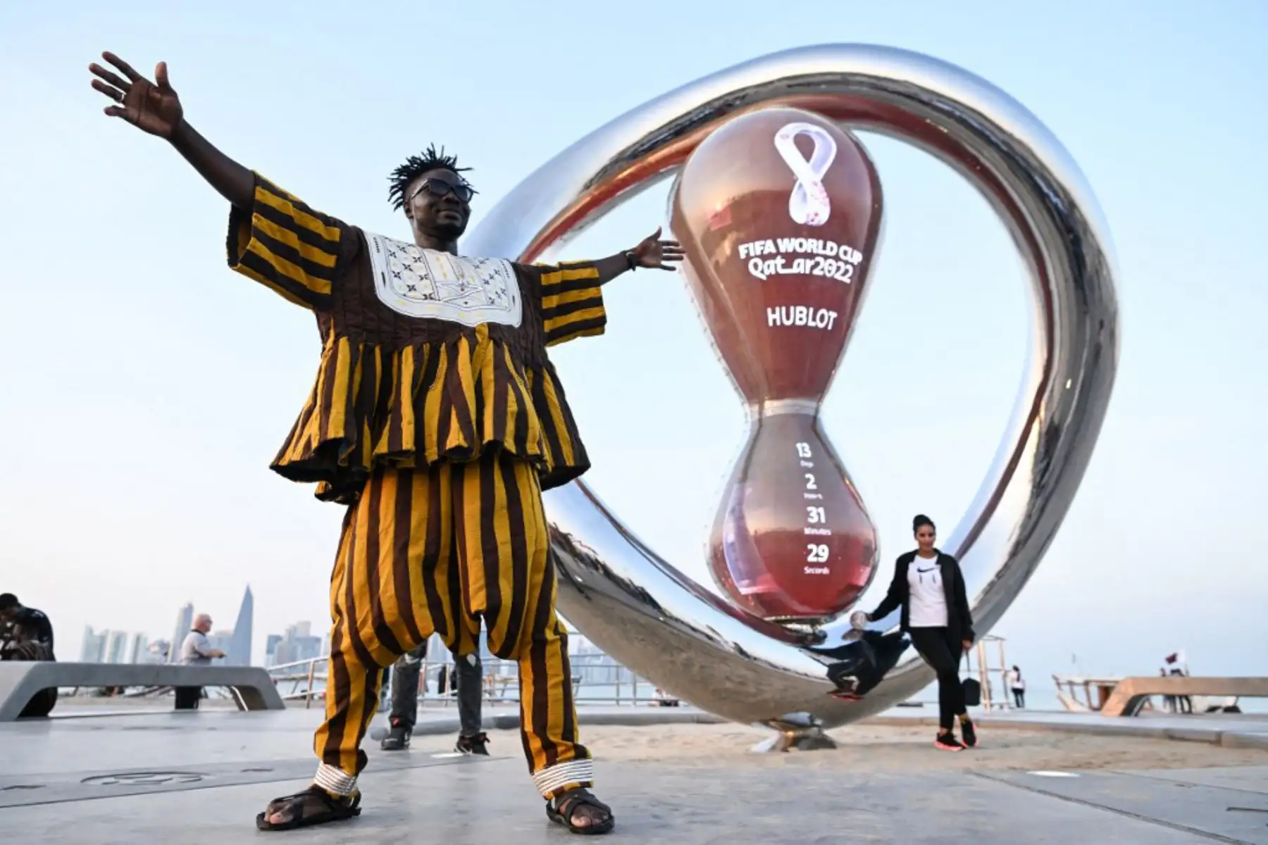 Un hincha de la selección nacional de fútbol de Ghana posa con el reloj de cuenta regresiva de la Copa Mundial de la FIFA en Doha. Foto: AFP