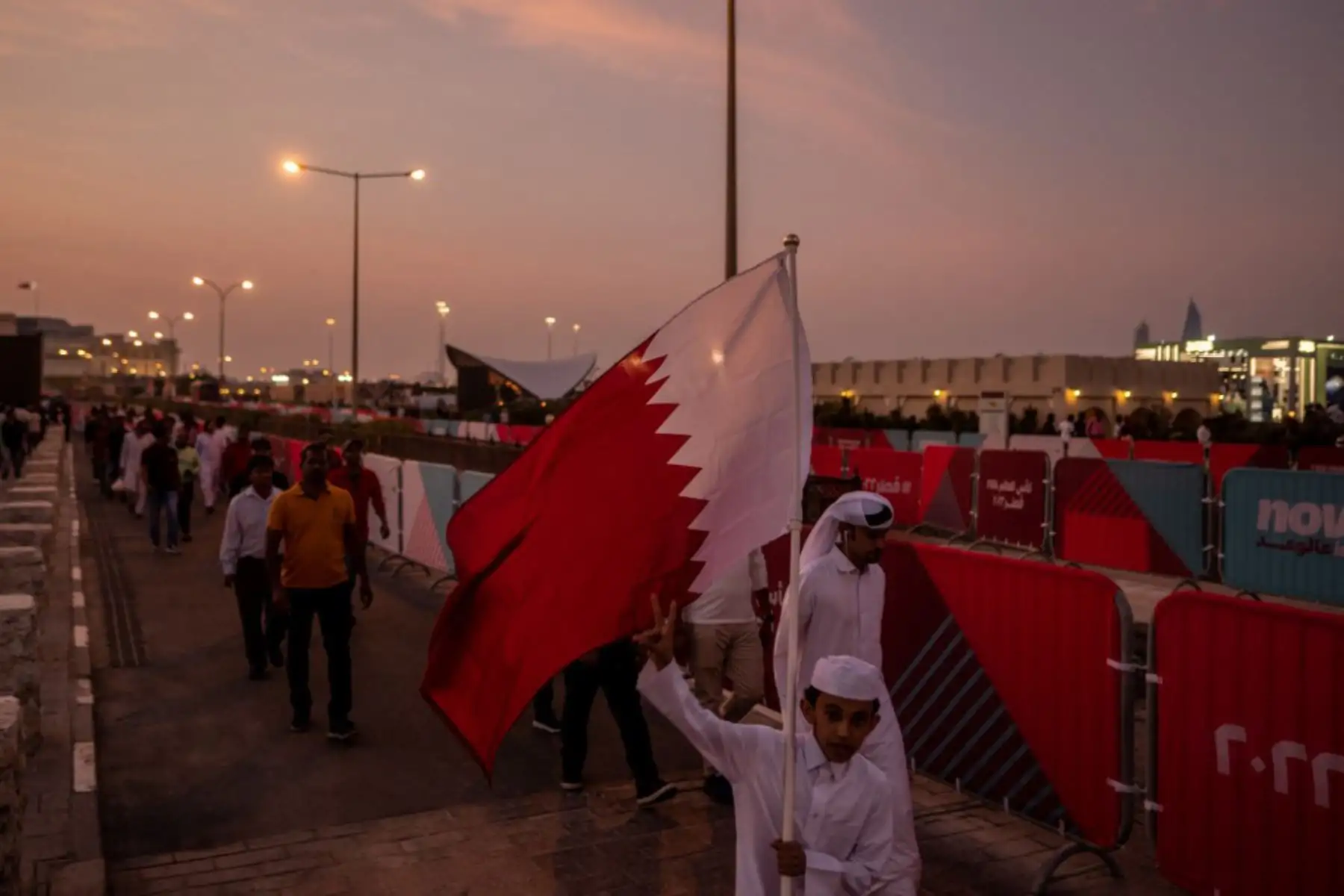 Un seguidor de Qatar sostiene la bandera nacional cerca del mercado de Souq Waqif en Doha, antes del torneo de fútbol de la Copa Mundial de Qatar 2022. Foto: AFP
