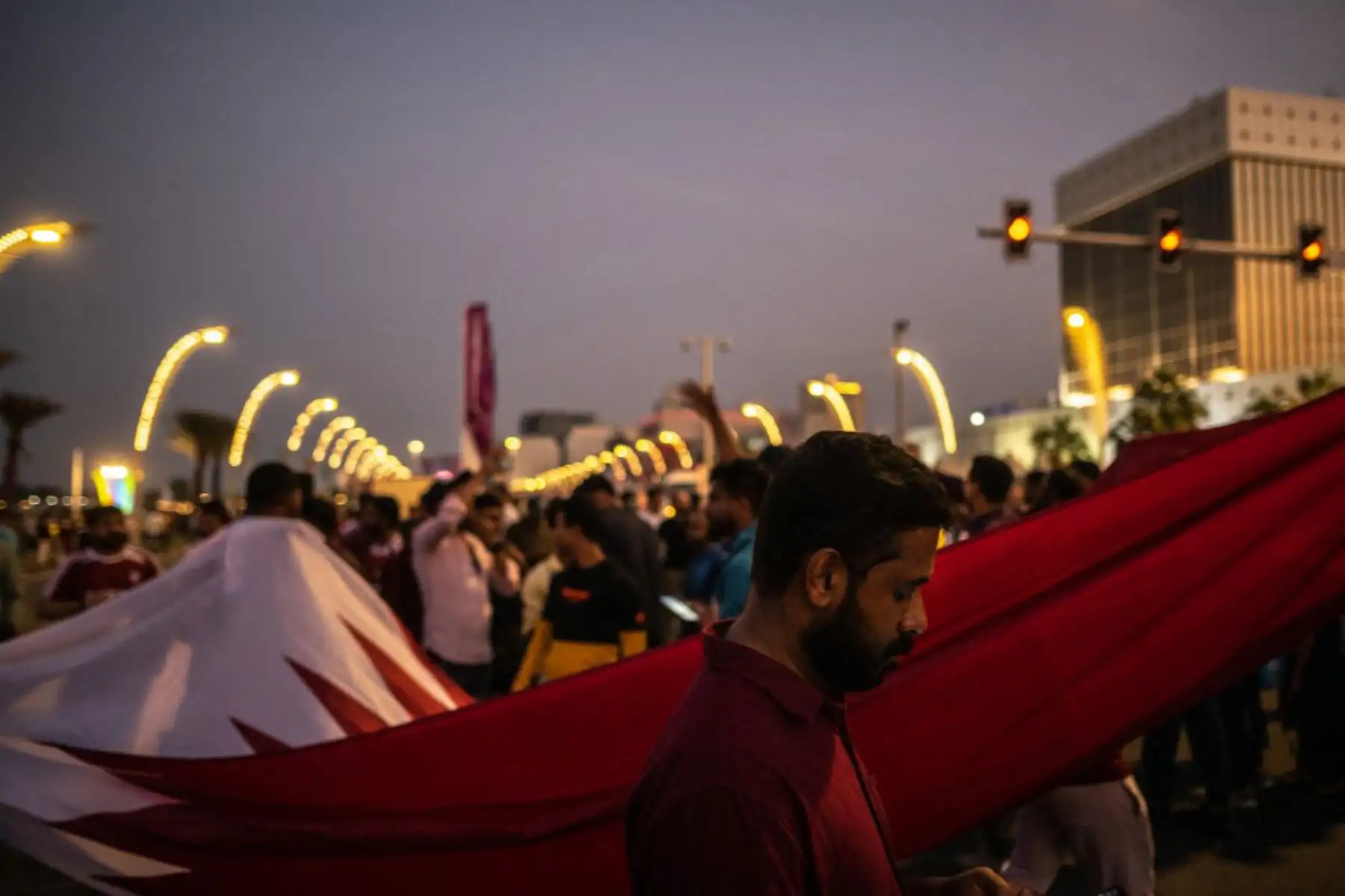 Los partidarios de Qatar marchan con la bandera nacional cerca del paseo Corniche en Doha. Foto: AFP