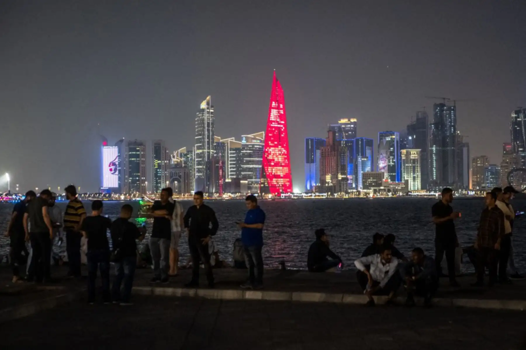 La gente se reúne en el paseo Corniche con el horizonte de Doha de fondo, antes del torneo de fútbol de la Copa Mundial de Qatar 2022. Foto: AFP