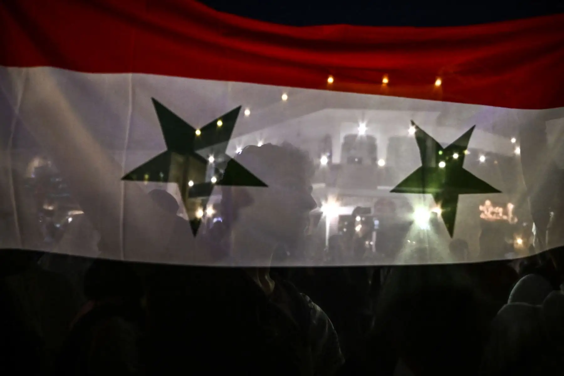 Un hombre sostiene una bandera nacional siria en el mercado de Souq Waqif en Doha, antes del torneo de fútbol de la Copa Mundial de Qatar 2022.

Foto: AFP