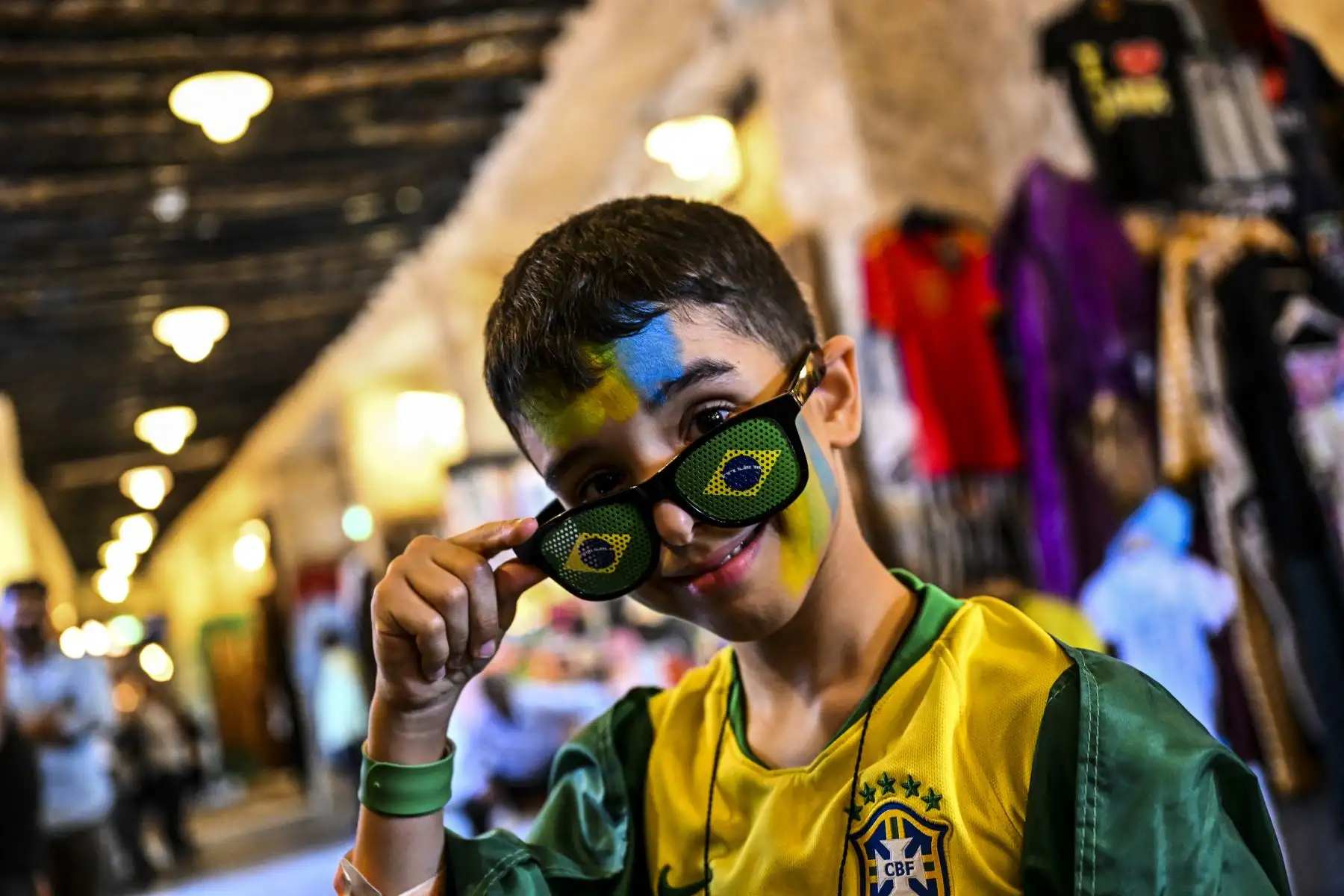 Un joven aficionado de Brasil posa en el mercado de Souq Waqif en Doha, antes del torneo de fútbol de la Copa Mundial de Qatar 2022.

Foto: AFP