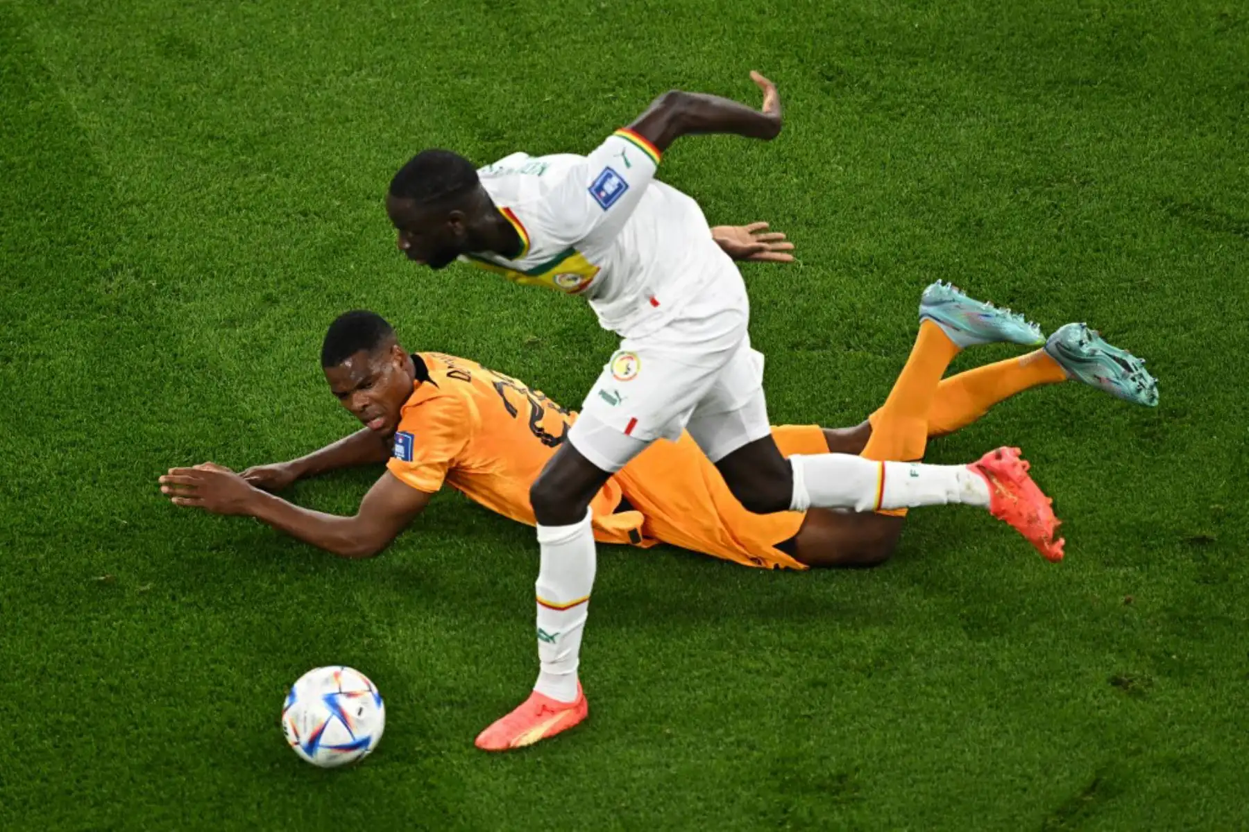 El defensor holandés Denzel Dumfries, lucha por el balón con el mediocampista senegalés Cheikhou Kouyate durante el partido de fútbol del Grupo A de la Copa Mundial Catar 2022. Foto: AFP