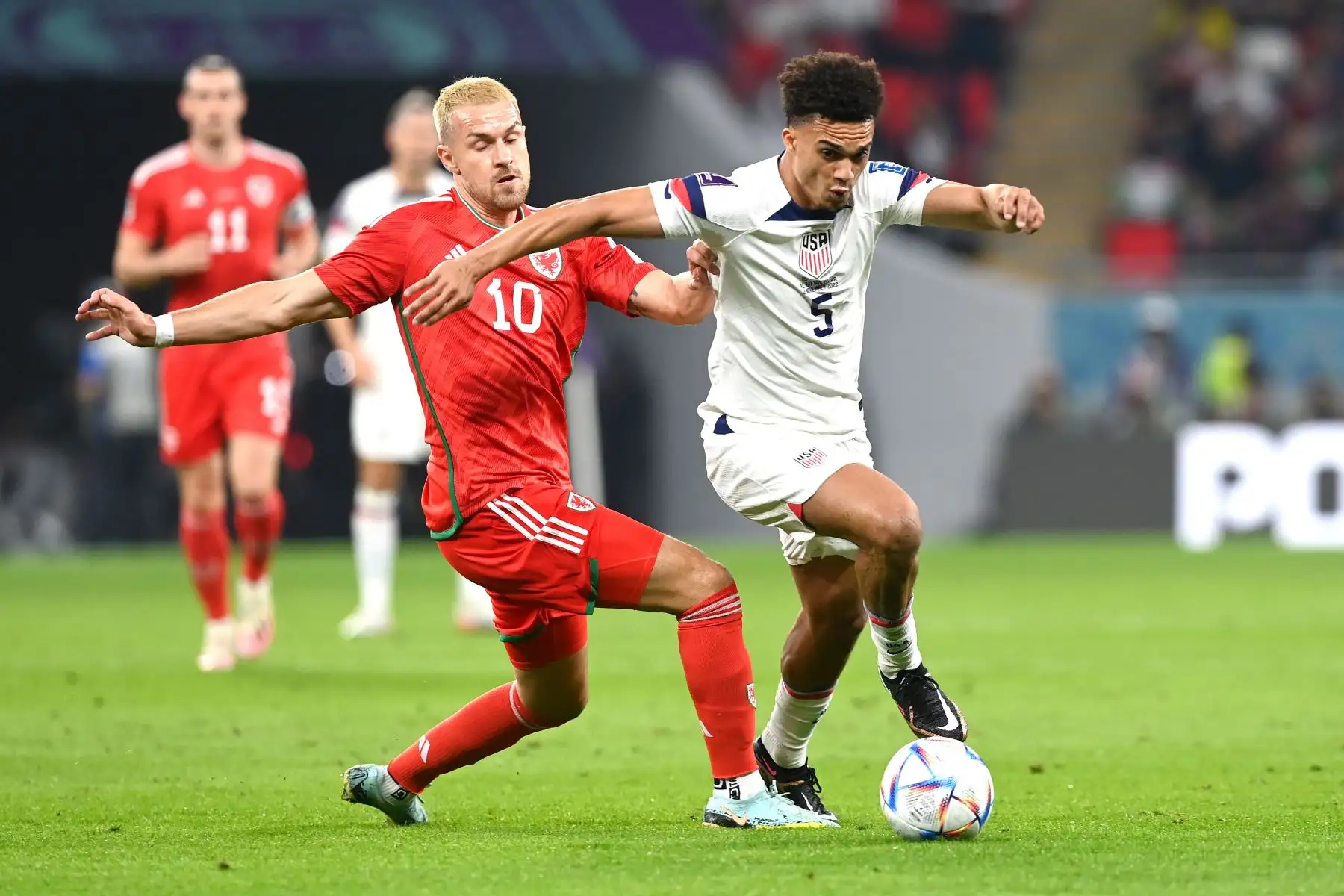 Antonee Robinson (R) de EE.UU. en acción contra Aaron Ramsey de Gales durante el partido de fútbol del grupo B de la Copa Mundial de la FIFA 2022 entre EE.UU. y Gales en el estadio Ahmad bin Ali de Doha, Catar, 21 de noviembre de 2022. Foto: EFE