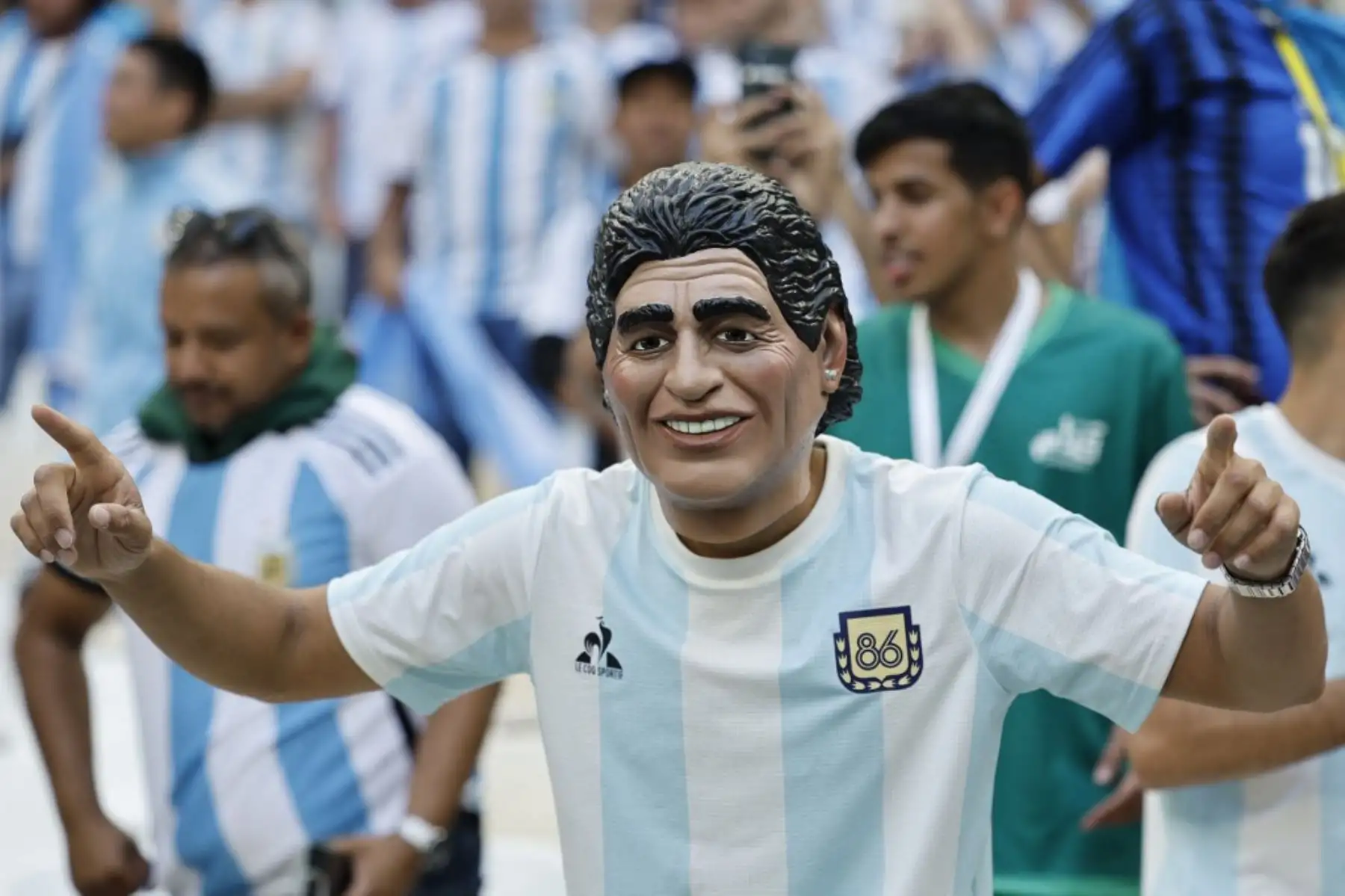 Un seguidor con una máscara que representa a la leyenda del fútbol Diego Maradona posa para fotografías antes del partido de fútbol del Grupo C de la Copa Mundial Catar 2022 entre Argentina y Arabia Saudita en el Estadio Lusail en Lusail, al norte de Doha. Foto: AFP