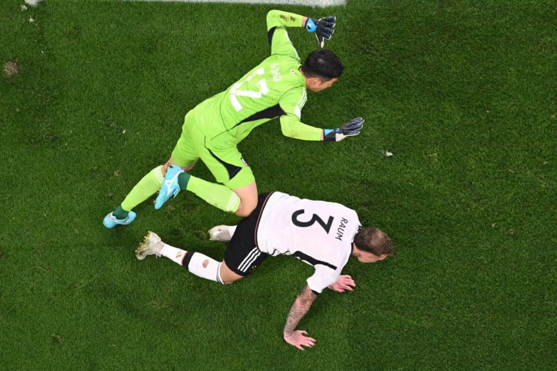 El defensa alemán David Raum  recibe una falta del portero japonés Shuichi Gonda durante el partido de fútbol del Grupo E de la Copa Mundial Catar 2022 entre Alemania y Japón en el Estadio Internacional Khalifa en Doha. Foto: EFE