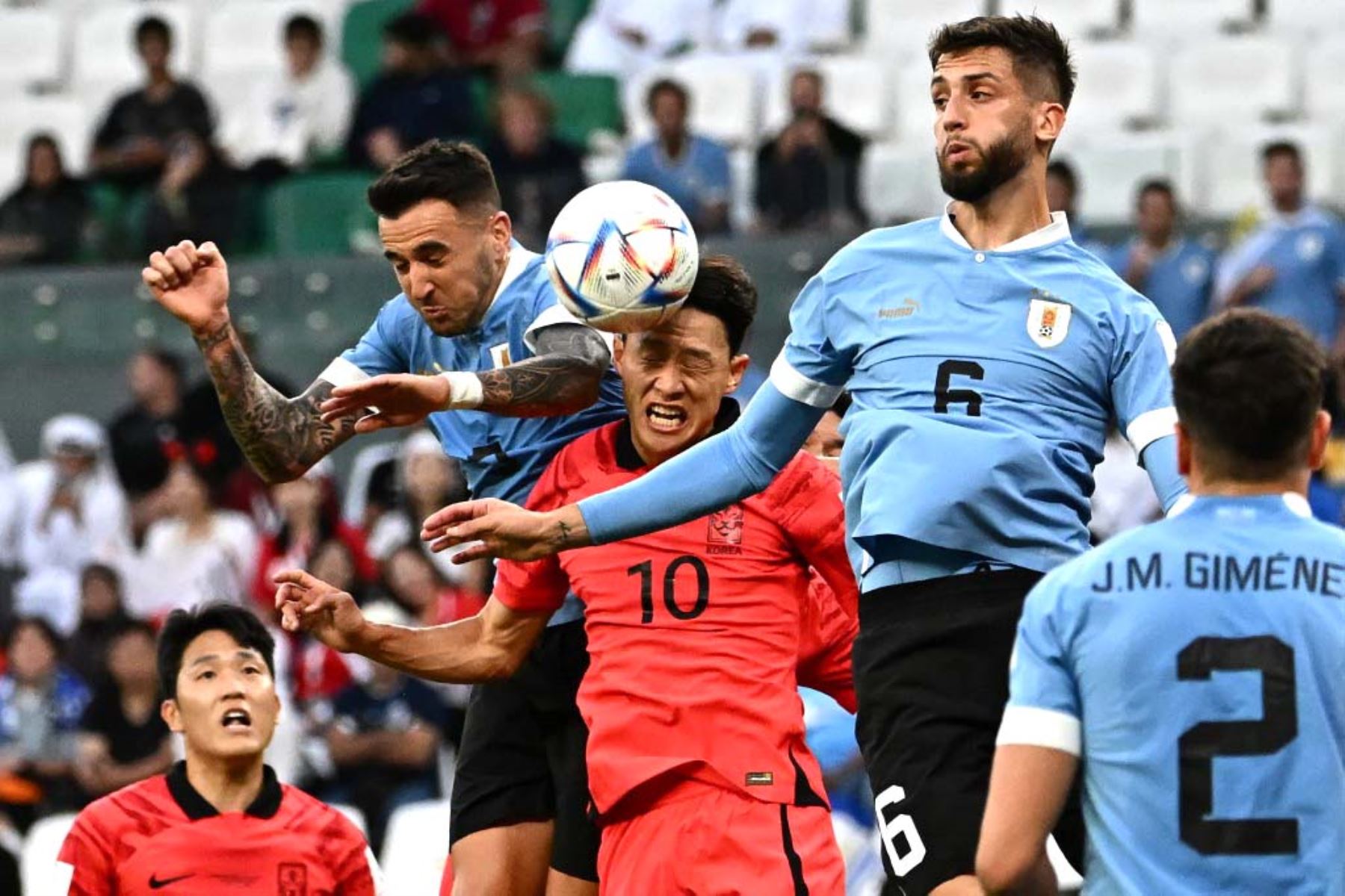 El mediocampista de Corea del Sur Lee Jae-sung y el  de Uruguay Rodrigo Bentancur saltan para cabecear el balón durante el partido de fútbol del Grupo H de la Copa Mundial de Catar 2022. Foto: AFP