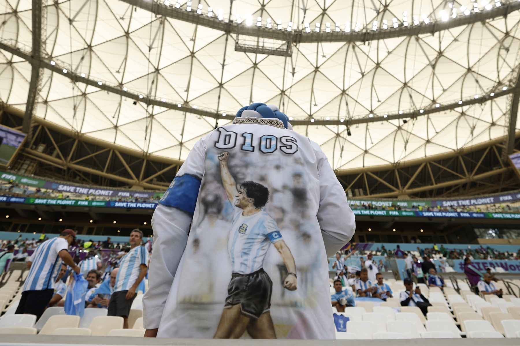 Un hincha de Argentina usa un abrigo con la imagen de Diego Armando Maradona. Foto: EFE