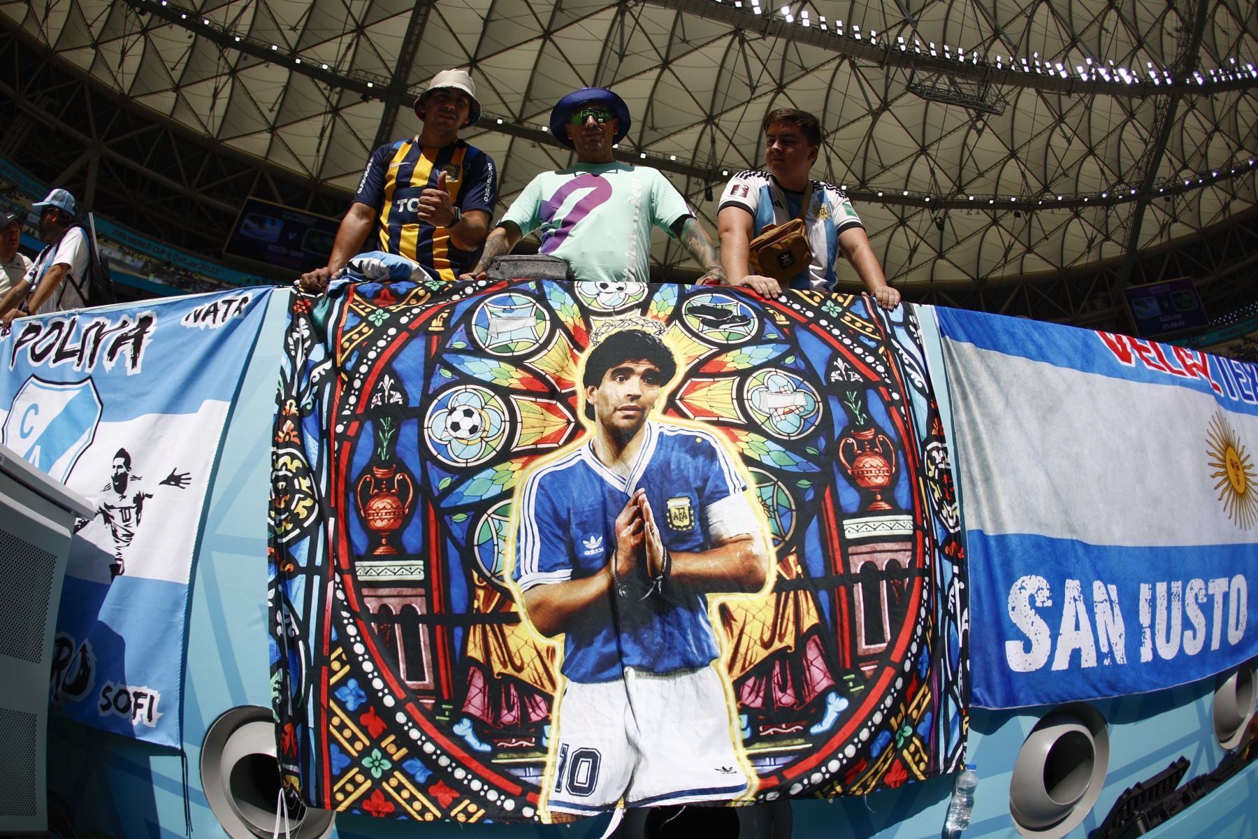 Hinchas de Argentina posan con una bandera con la imagen de Diego Armando Maradona. Foto: EFE