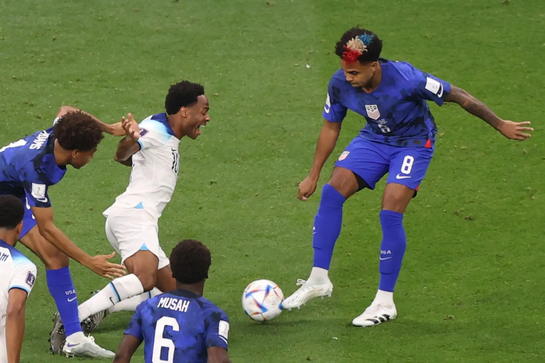 Raheem Sterling de Inglaterra en acción contra Tyler Adams  y Weston McKennie de los EE. UU. durante el partido de fútbol del grupo B de la Copa Mundial de la FIFA 2022 entre Inglaterra y los EE. UU. En el estadio Al Bayt en Al Khor, Catar, el 25 de noviembre de 2022. Foto: EFE