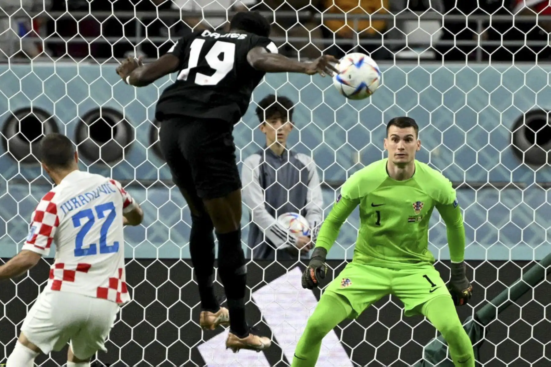 El delantero canadiense #19 Alphonso Davies cabecea el balón para marcar el primer gol de su equipo superando al portero croata #01 Dominik Livakovic durante el partido de fútbol del Grupo F de la Copa Mundial Catar 2022 entre Croacia y Canadá en el Estadio Internacional Khalifa en Doha

Foto: AFP