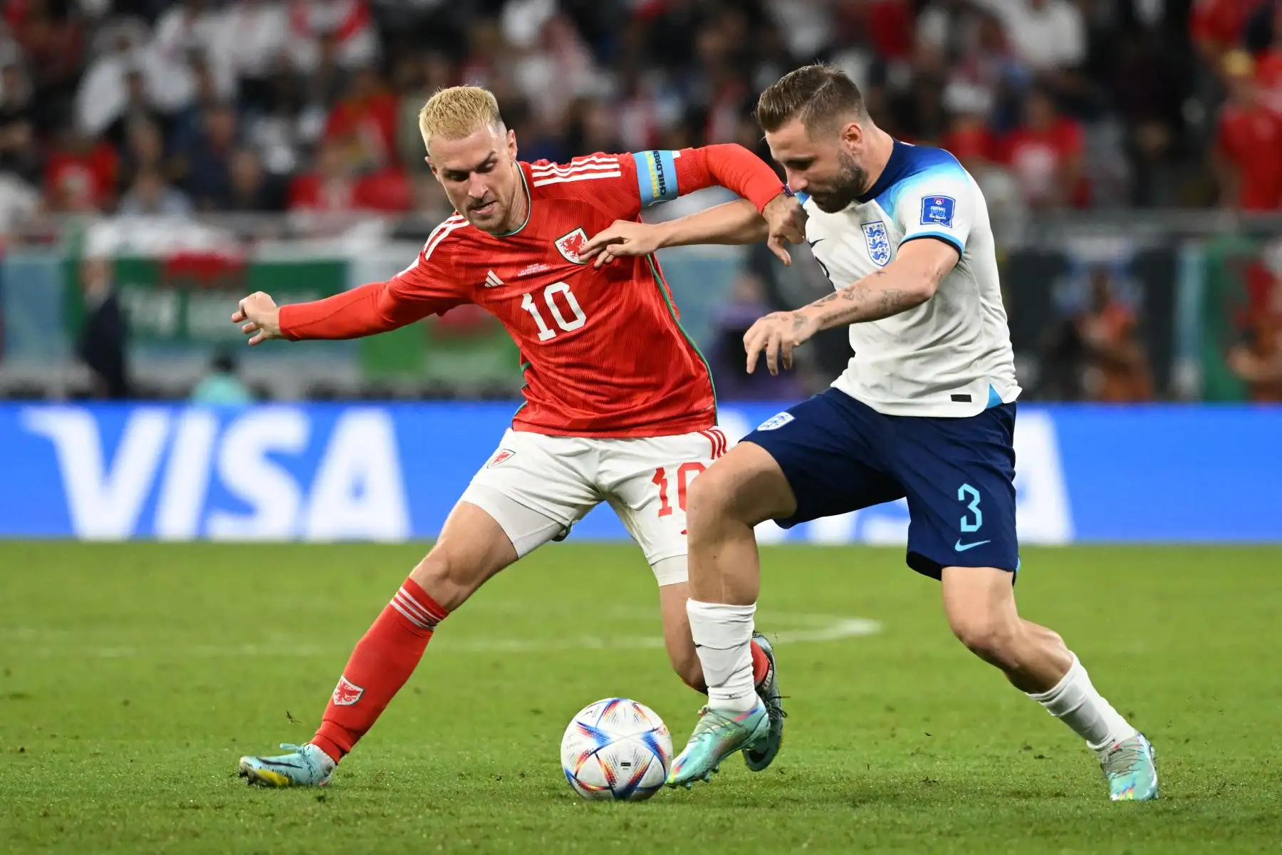 El mediocampista de Gales Aaron Ramsey lucha por el balón con el defensor de Inglaterra Luke Shaw durante el partido de fútbol del Grupo B de la Copa Mundial de Catar 2022 entre Gales e Inglaterra en el estadio Ahmad Bin Ali en Al-Rayyan, al oeste de Doha el 29 de noviembre de 2022. Foto: AFP