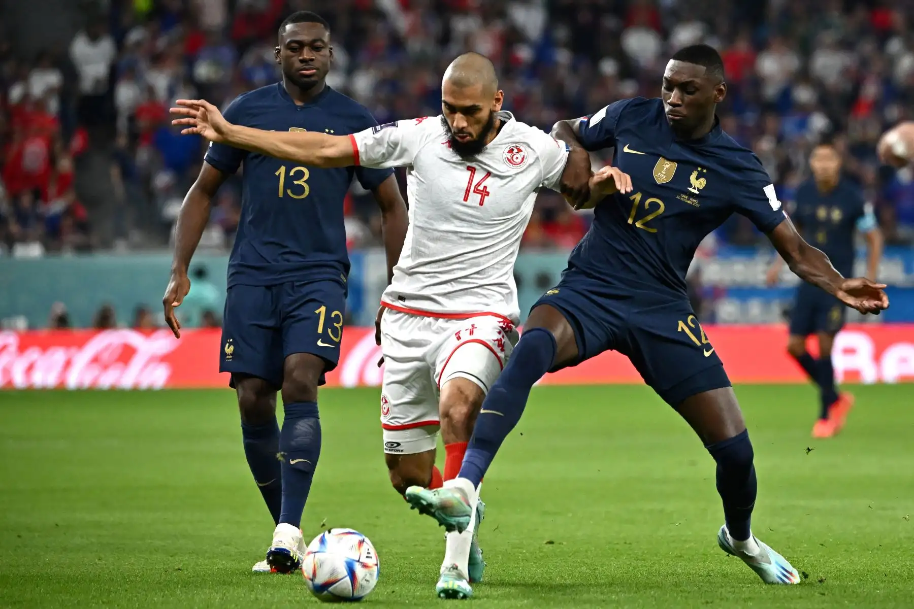 El mediocampista francés  Youssouf Fofana y el delantero francés Randal Kolo Muani luchan por el balón con la mediocampista tunecina  Aissa Laidouni durante el partido de fútbol del Grupo D de la Copa Mundial de Catar 2022. Foto: AFP