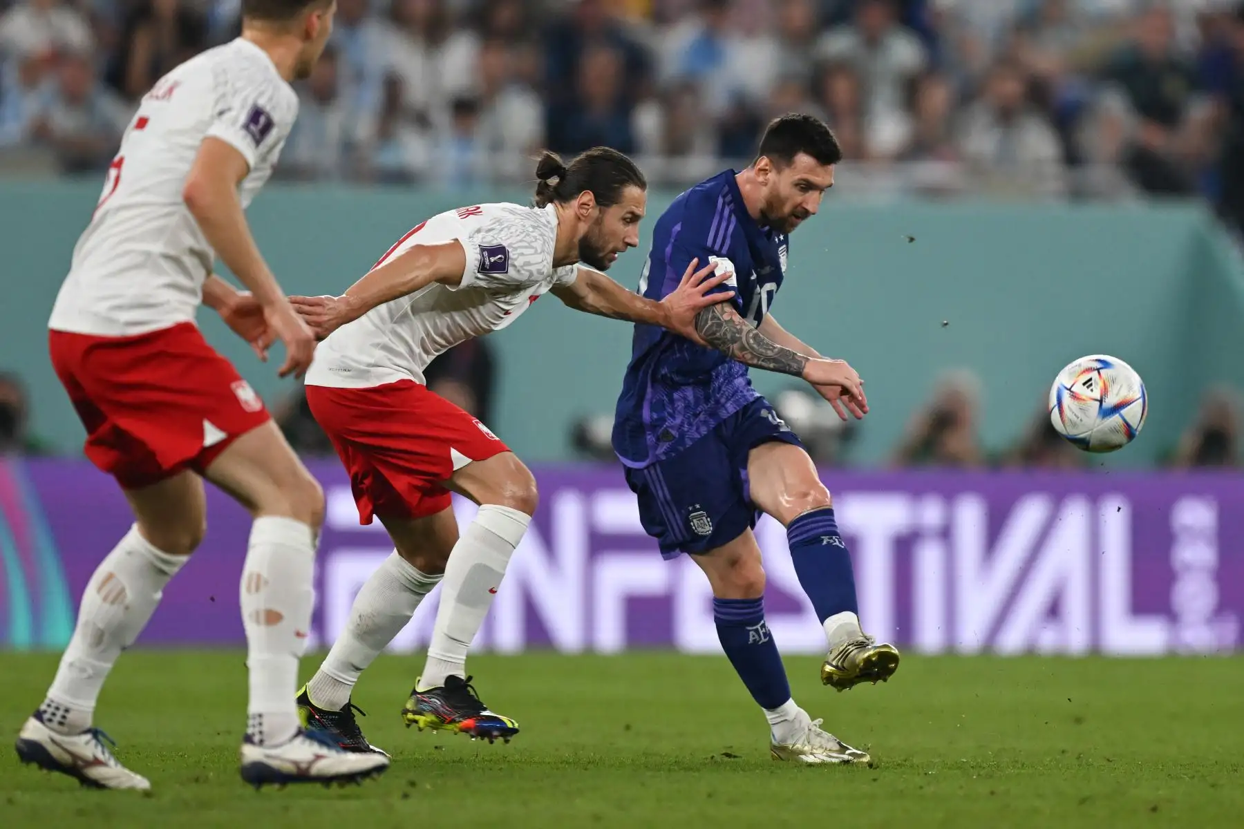 El delantero argentino Lionel Messi patea el balón más allá del mediocampista polaco Grzegorz Krychowiak durante el partido de fútbol del Grupo C de la Copa Mundial Catar 2022 entre Polonia y Argentina en el Estadio 974 en Doha el 30 de noviembre de 2022. Foto: AFP