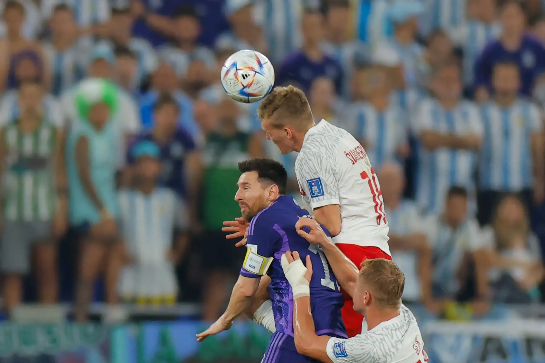 El delantero polaco #16 Karol Swiderski  dirige el balón más allá del delantero argentino Lionel Messi (centro) y el defensor polaco  Kamil Glik durante el partido de fútbol del Grupo C de la Copa Mundial Catar 2022 entre Polonia y Argentina en el Estadio 974 en Doha en noviembre 30 de enero de 2022. Foto: AFP