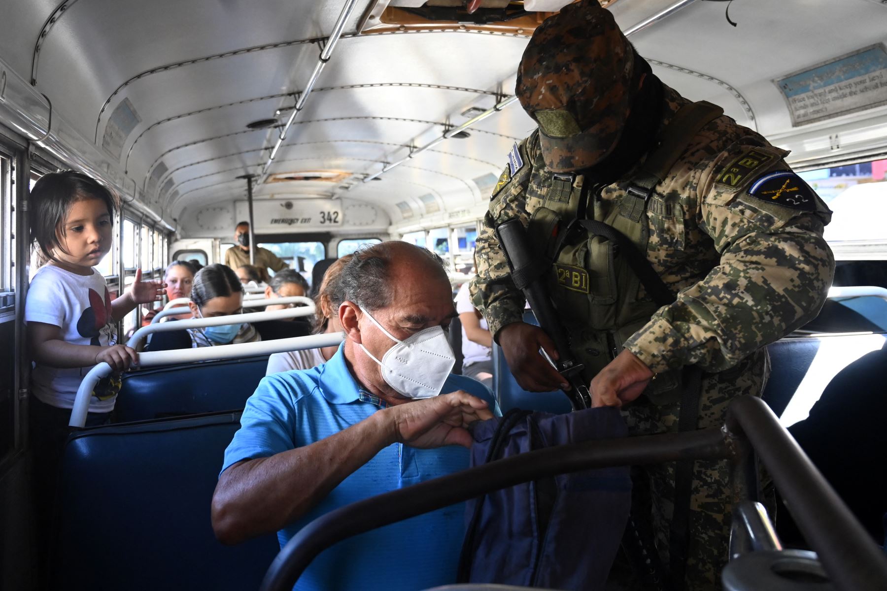 Un soldado revisa las pertenencias de un pasajero dentro de un autobús durante una operación contra pandilleros, en Soyapango, El Salvador, el 5 de diciembre de 2022. 
Foto: AFP
