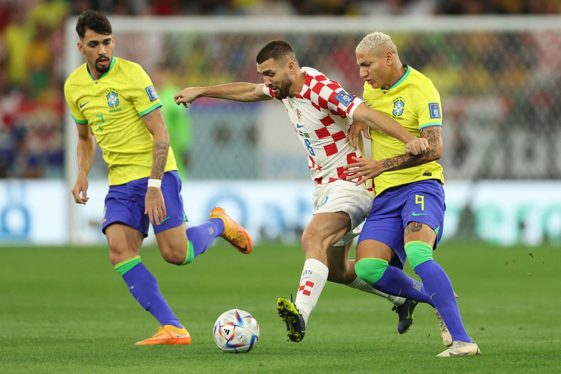 El mediocampista croata Mateo Kovacic lucha por el balón con el mediocampista brasileño Lucas Paquetá y el delantero brasileño Richarlison durante el partido de fútbol de cuartos de final de la Copa Mundial Qatar 2022 entre Croacia y Brasil 
Foto: AFP