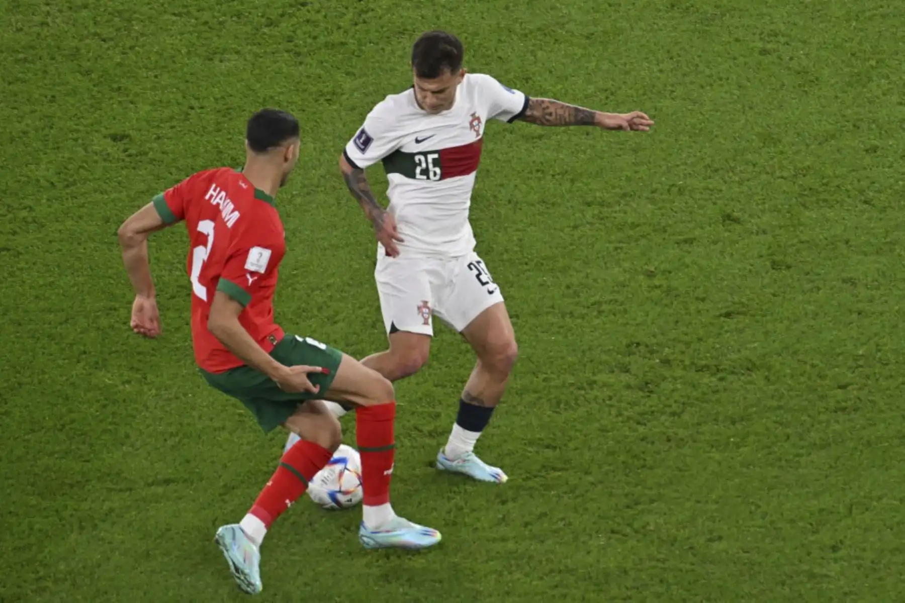 El defensor de Marruecos #02 Achraf Hakimi y el delantero de Portugal #26 Goncalo Ramos luchan por el balón durante el partido de cuartos de final de la Copa del Mundo de Catar 2022 entre Marruecos y Portugal en el Estadio Al-Thumama en Doha

Foto: AFP