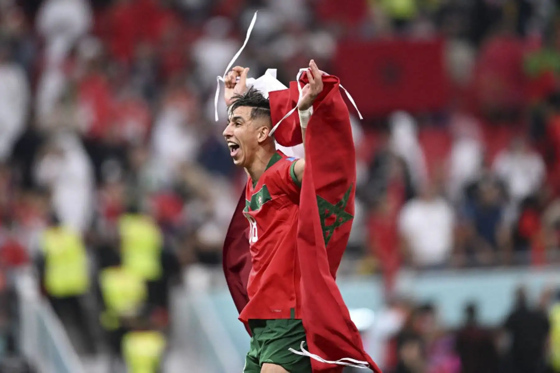 El defensor de Marruecos #18 Jawad El Yamiq ondea su bandera nacional mientras celebra ganar el partido de fútbol de cuartos de final de la Copa Mundial de Catar 2022 entre Marruecos y Portugal en el Estadio Al-Thumama en Doha

Foto:AFP