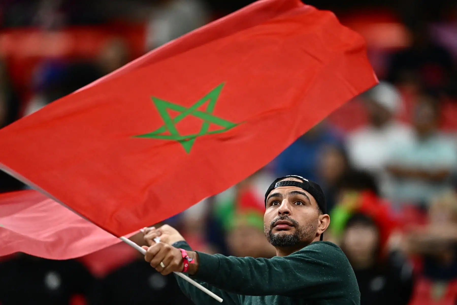 Un partidario de Marruecos ondea una bandera nacional en las gradas antes del partido de semifinales de fútbol de la Copa Mundial de Catar 2022 entre Francia y Marruecos en el estadio Al-Bayt en Al Khor, al norte de Doha

Foto: AFP