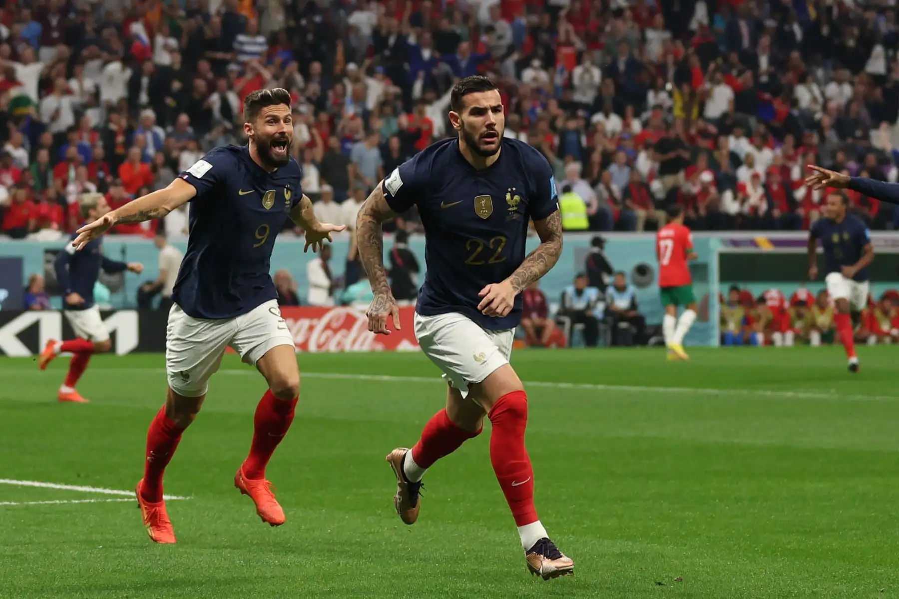El defensor francés #22 Theo Hernández celebra, con el delantero francés #09 Olivier Giroud corriendo detrás, luego de anotar el primer gol de su equipo durante el partido de fútbol de semifinales de la Copa Mundial Catar 2022 entre Francia y Marruecos en el estadio Al-Bayt en Al Khor, norte de Doha