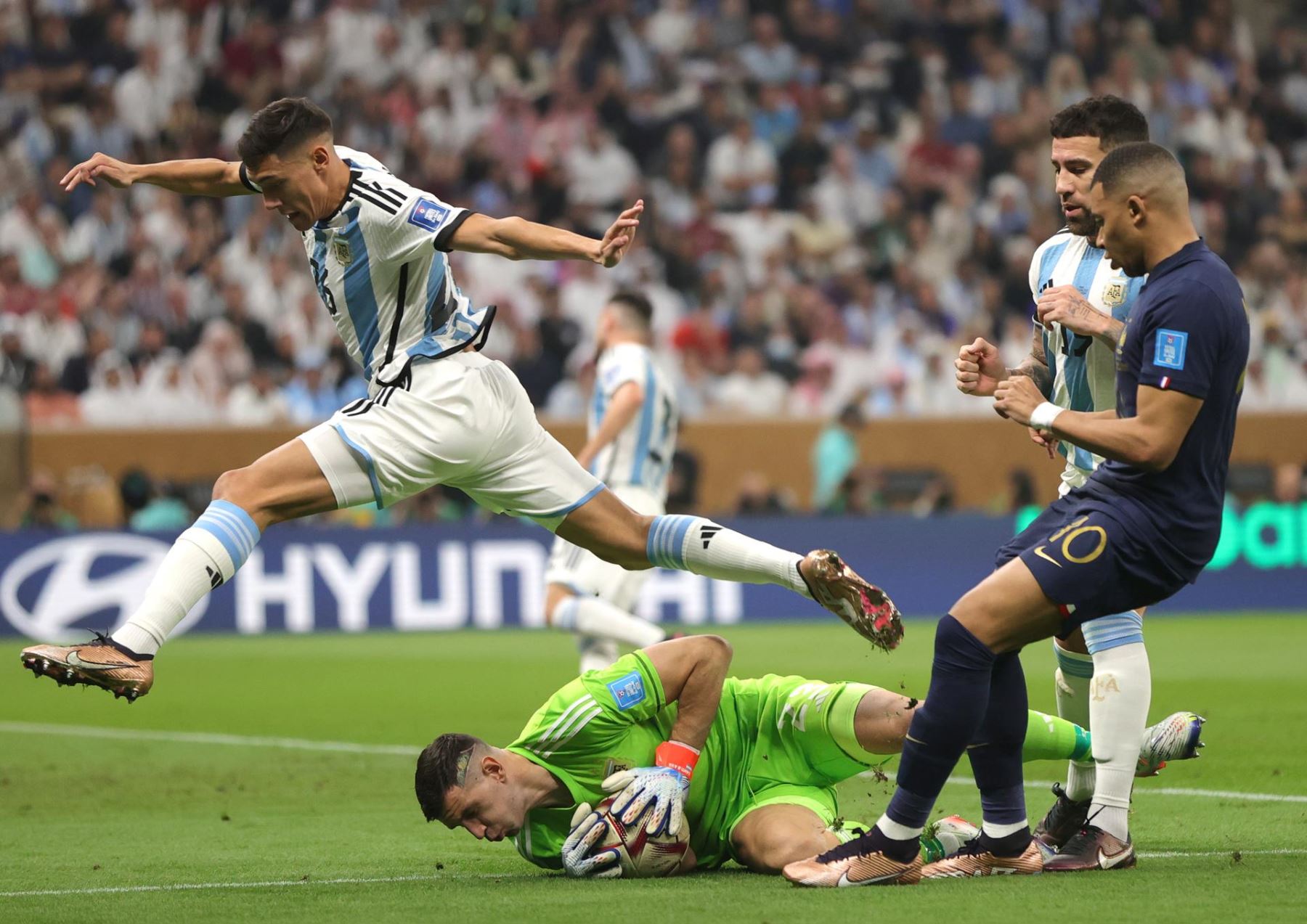 El arquero argentino Damián Martínez salva el balón junto a Kylian Mbappé durante la final de la Copa Mundial de la FIFA 2022 entre Argentina y Francia en el Estadio Lusail de Lusail, Qatar, el 18 de diciembre de 2022. 
Foto: EFE