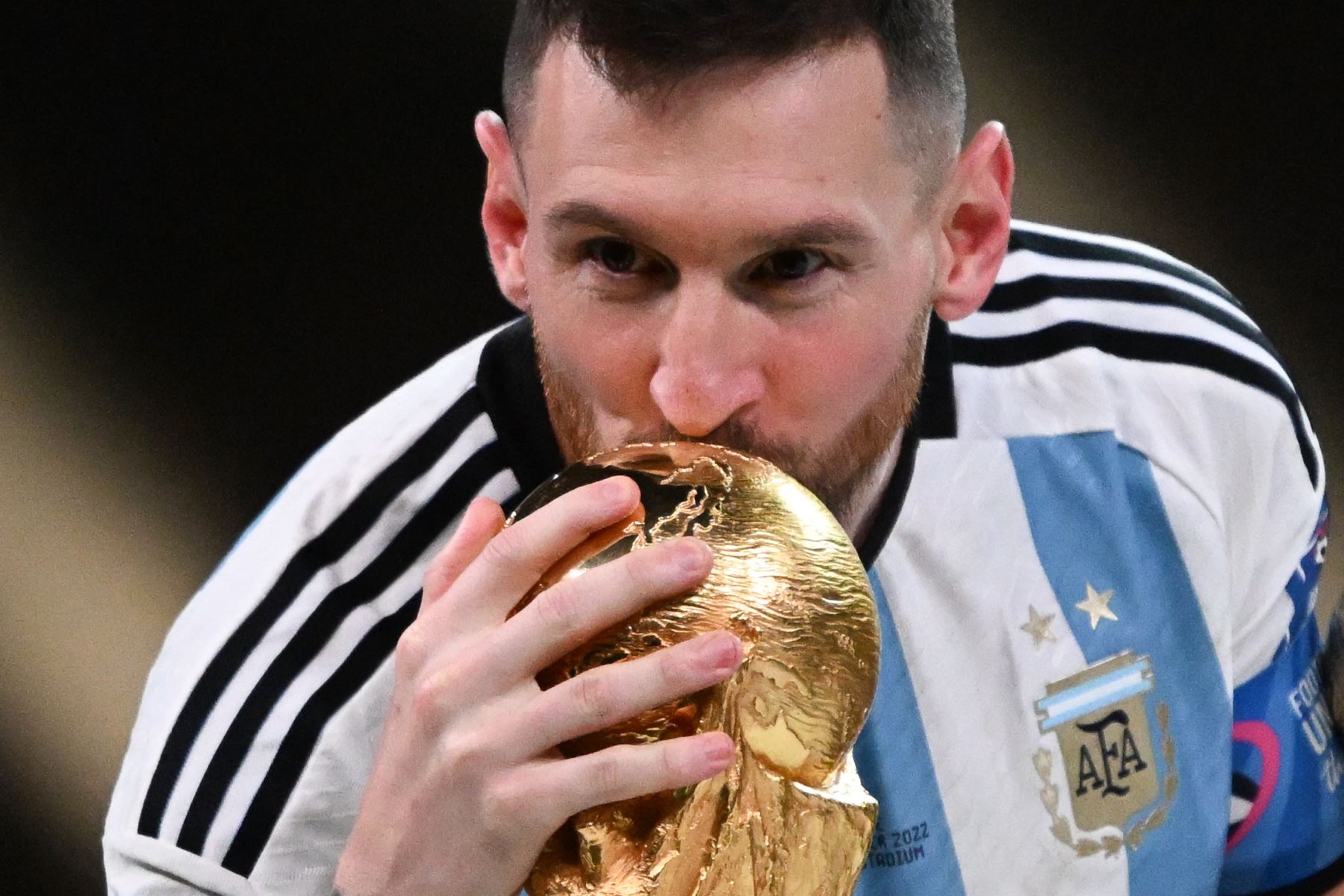 Lionel Messi de Argentina besa el trofeo de la Copa del Mundo mientras lo pasa con su trofeo al mejor jugador de la final de la Copa Mundial de la FIFA 2022 entre Argentina y Francia en el estadio Lusail, Lusail, Qatar, el 18 de diciembre de 2022.Foto: EFE
