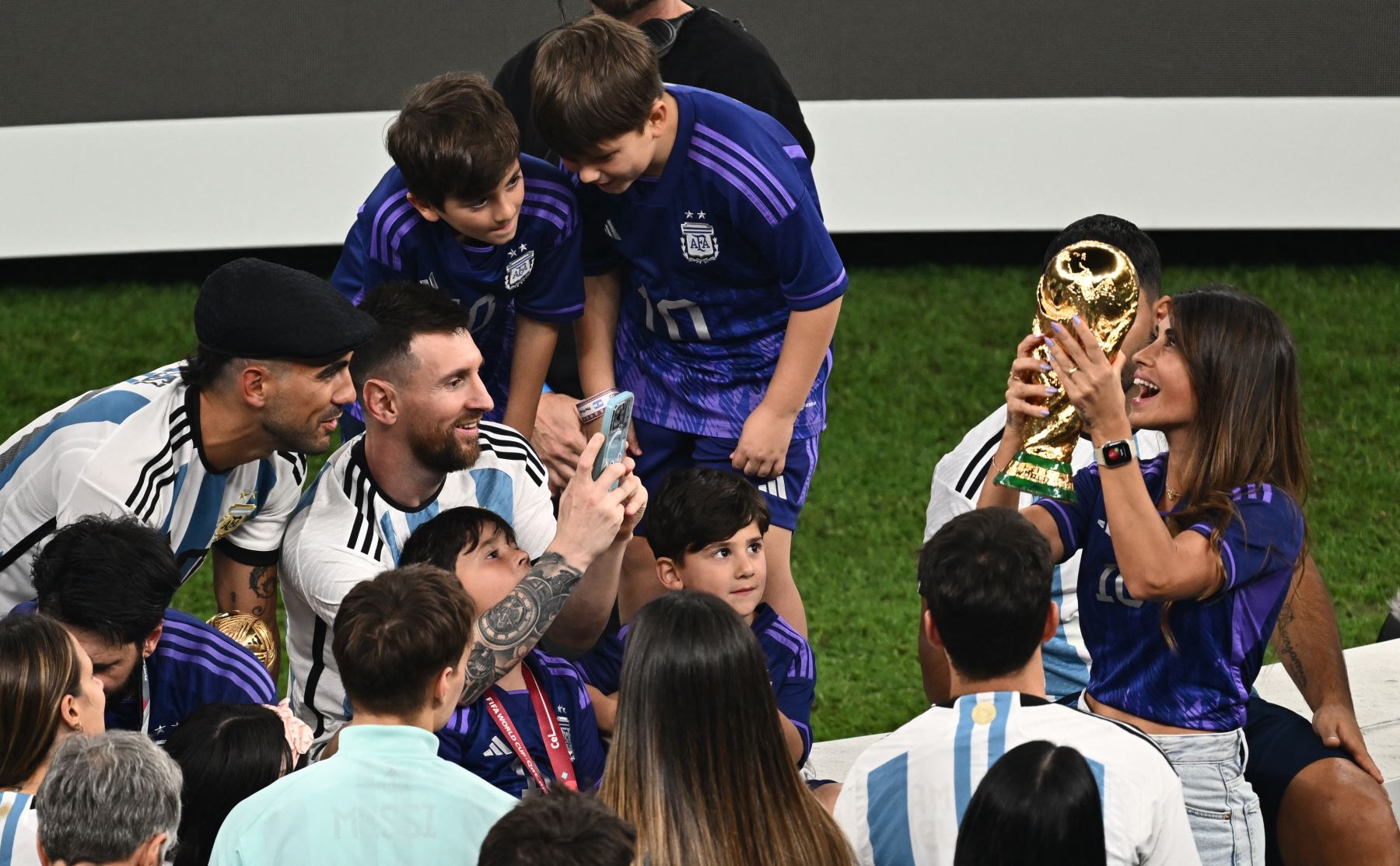 El delantero argentino Lionel Messi toma fotografías de su esposa Antonela Roccuzzo sosteniendo el Trofeo de la Copa Mundial al final del partido de fútbol final de la Copa Mundial Qatar 2022 entre Argentina y Francia en el Estadio Lusail en Lusail, al norte de Doha el 18 de diciembre de 2022.
Foto: AFP