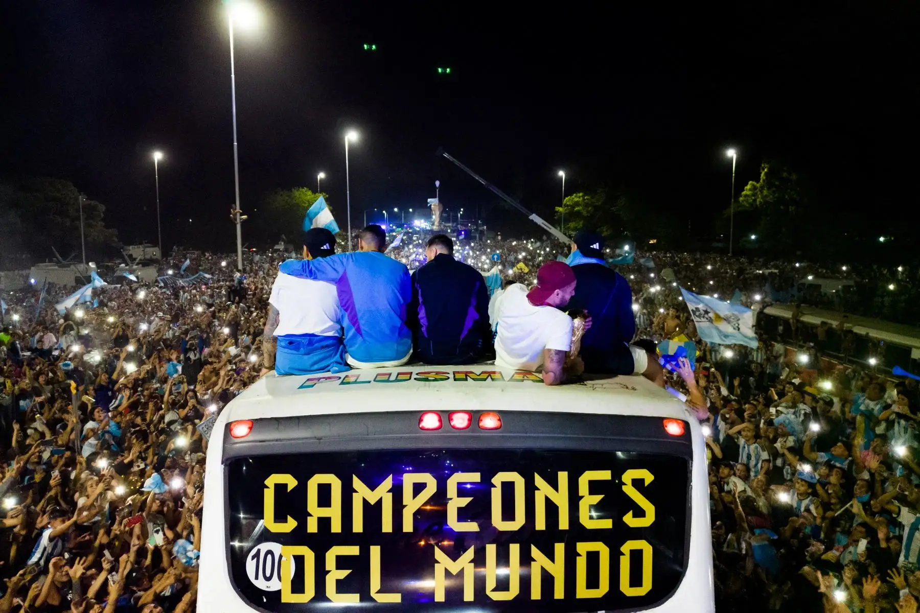 Los jugadores de Argentina celebran a bordo de un autobús con un cartel que dice "Campeones del Mundo" con seguidores después de ganar el torneo de la Copa Mundial de Qatar 2022 cuando salen del Aeropuerto Internacional de Ezeiza camino al centro de entrenamiento de la Asociación del Fútbol Argentino (AFA) en Ezeiza, provincia de Buenos Aires.
Foto: AFP
