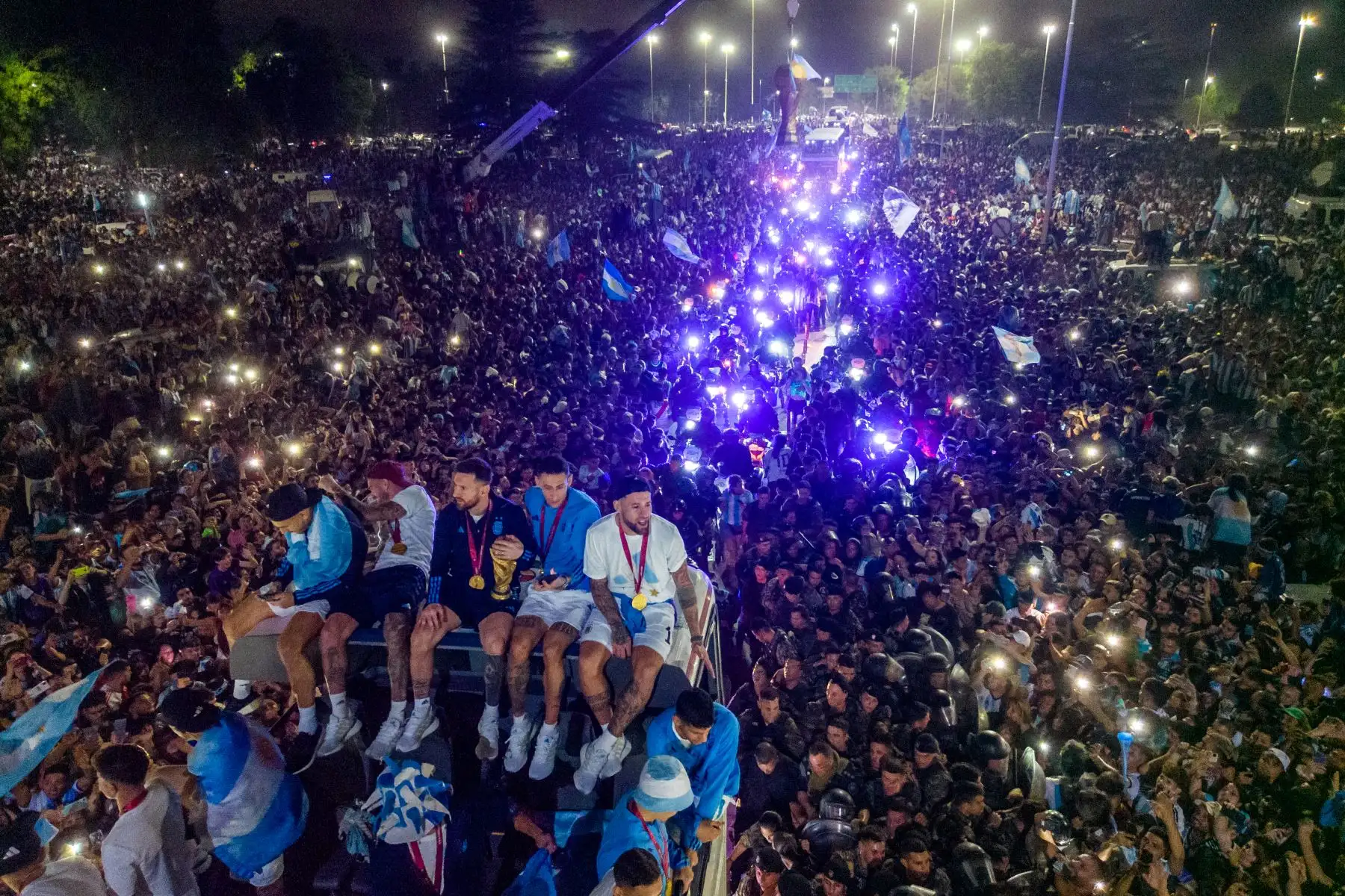 El capitán y delantero de Argentina, Lionel Messi, sostiene el Trofeo de la Copa Mundial de la FIFA a bordo de un autobús mientras celebra junto a sus compañeros y seguidores después de ganar el torneo de la Copa Mundial Qatar 2022 en Ezeiza, provincia de Buenos Aires, Argentina, el 20 de diciembre de 2022.
Foto: AFP