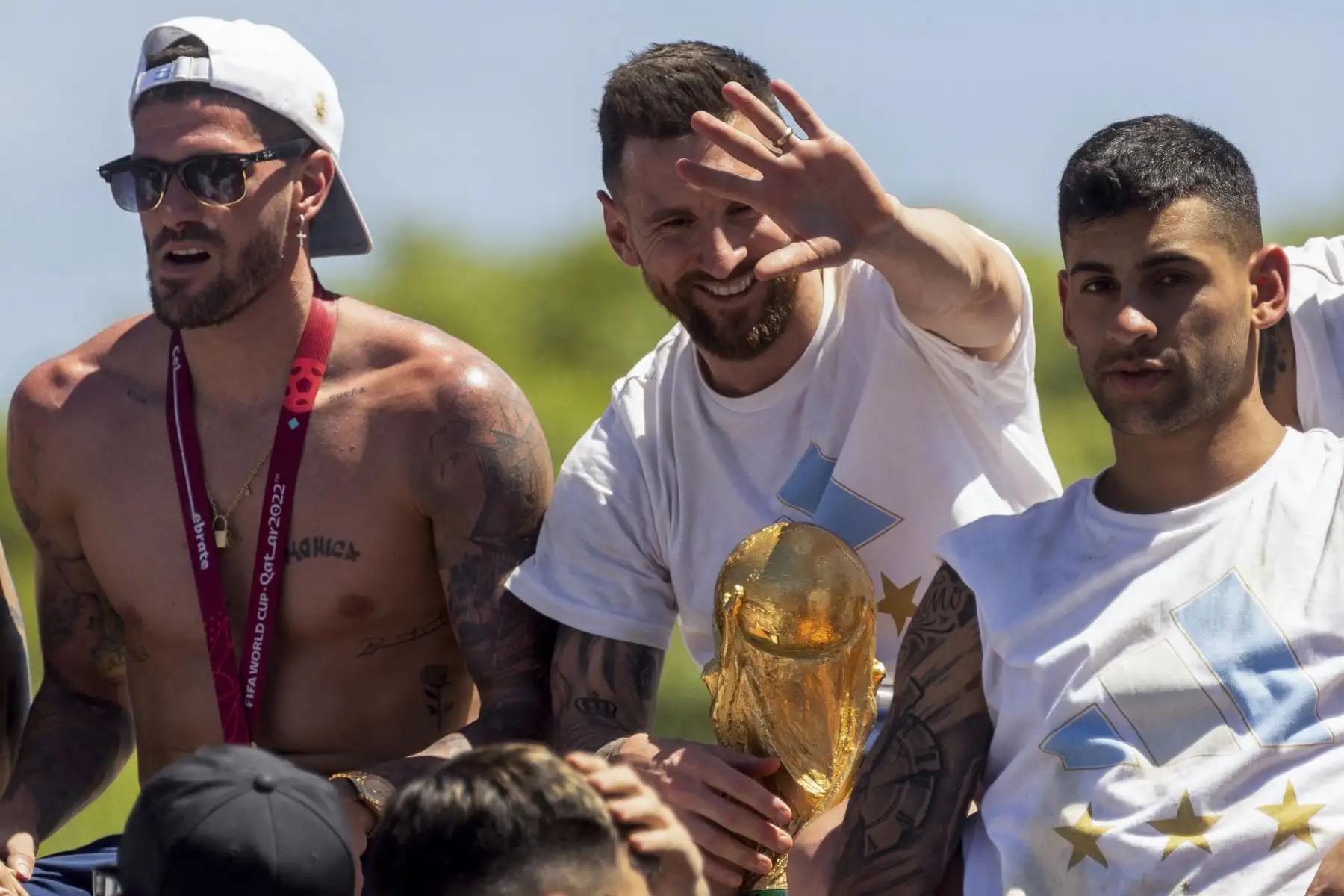 Los jugadores argentinos Rodrigo De Paul, Lionel Messi  y Cristian Romero  celebran a bordo de un autobús con un cartel que dice "Campeones del Mundo" con sus seguidores después de ganar el torneo de la Copa Mundial de Qatar 2022 mientras recorren Buenos Aires. en el centro de la ciudad el 20 de diciembre de 2022 Foto: AFP