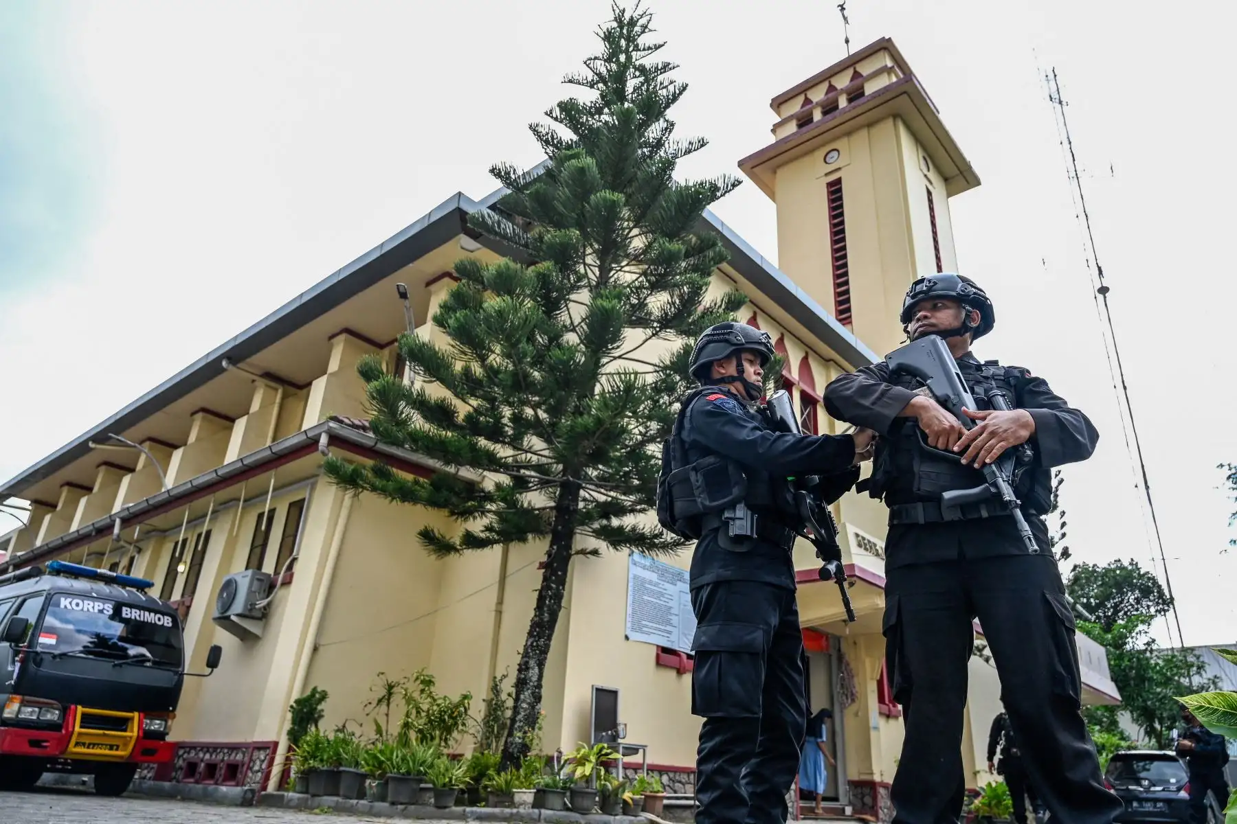 Agentes de la policía antiterrorista hacen guardia mientras revisan la seguridad en una iglesia católica antes de la víspera de Navidad en Banda Aceh el 24 de diciembre de 2022. Foto: AFP